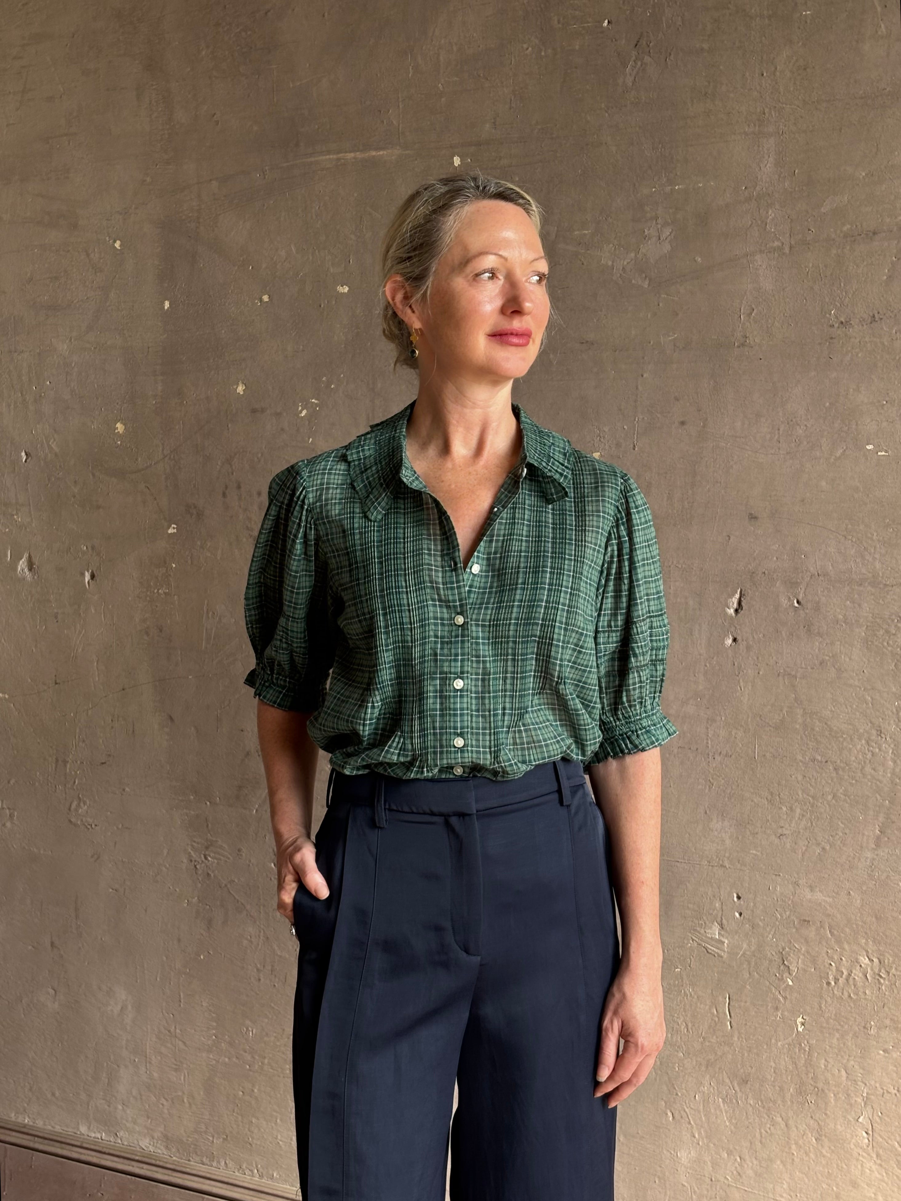 Mature woman wearing Trovata Jess green plaid short sleeve cotton poplin blouse with pintucking and peter pan collar