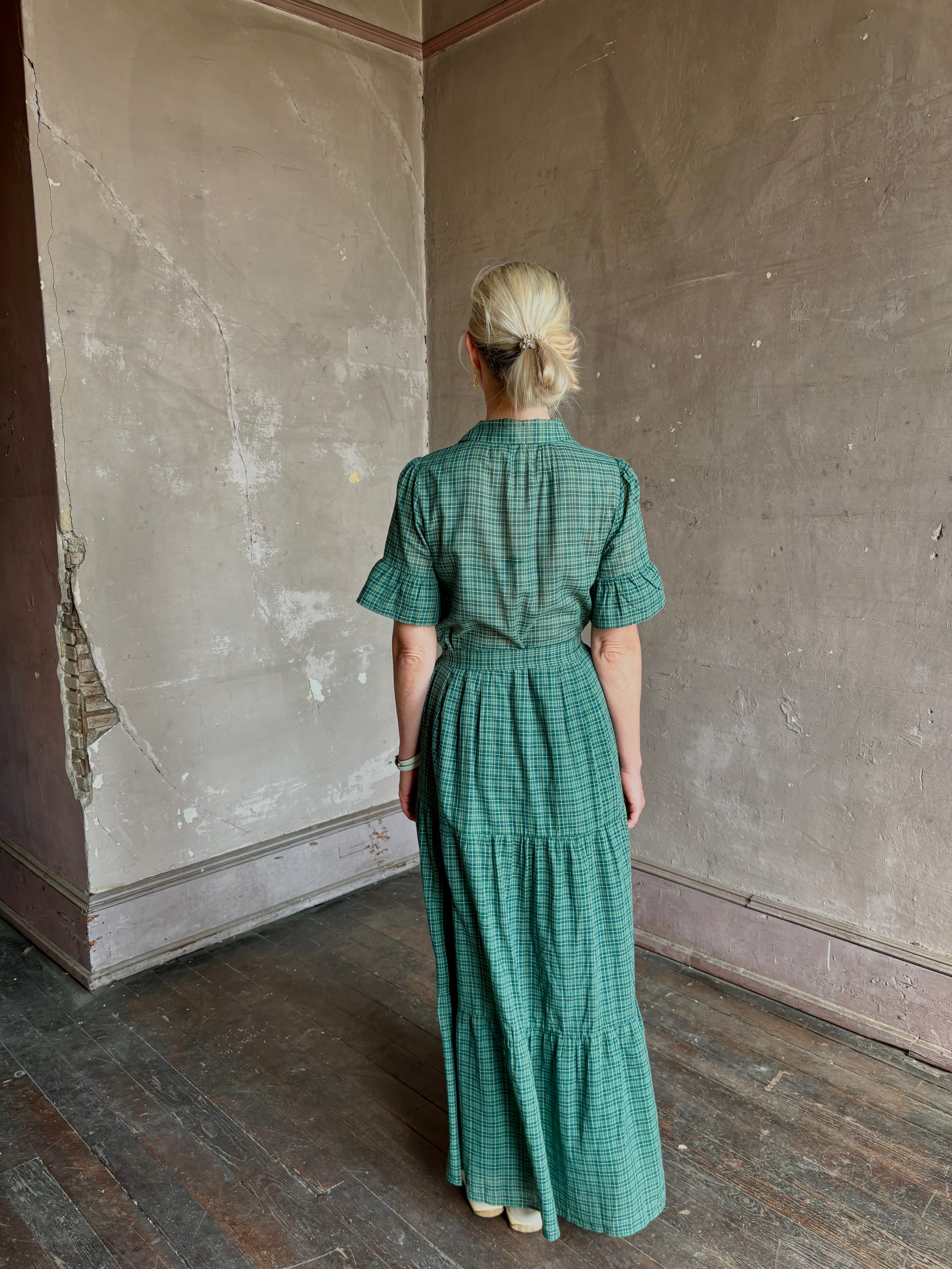 Mature woman wearing Trovata Martine button-up front cotton poplin green plaid maxi dress short sleeves and lightweight