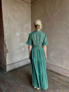 Mature woman wearing Trovata Martine button-up front cotton poplin green plaid maxi dress short sleeves and lightweight
