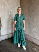 Mature woman wearing Trovata Martine button-up front cotton poplin green plaid maxi dress short sleeves and lightweight