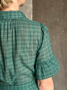 Mature woman wearing Trovata Martine button-up front cotton poplin green plaid maxi dress short sleeves and lightweight