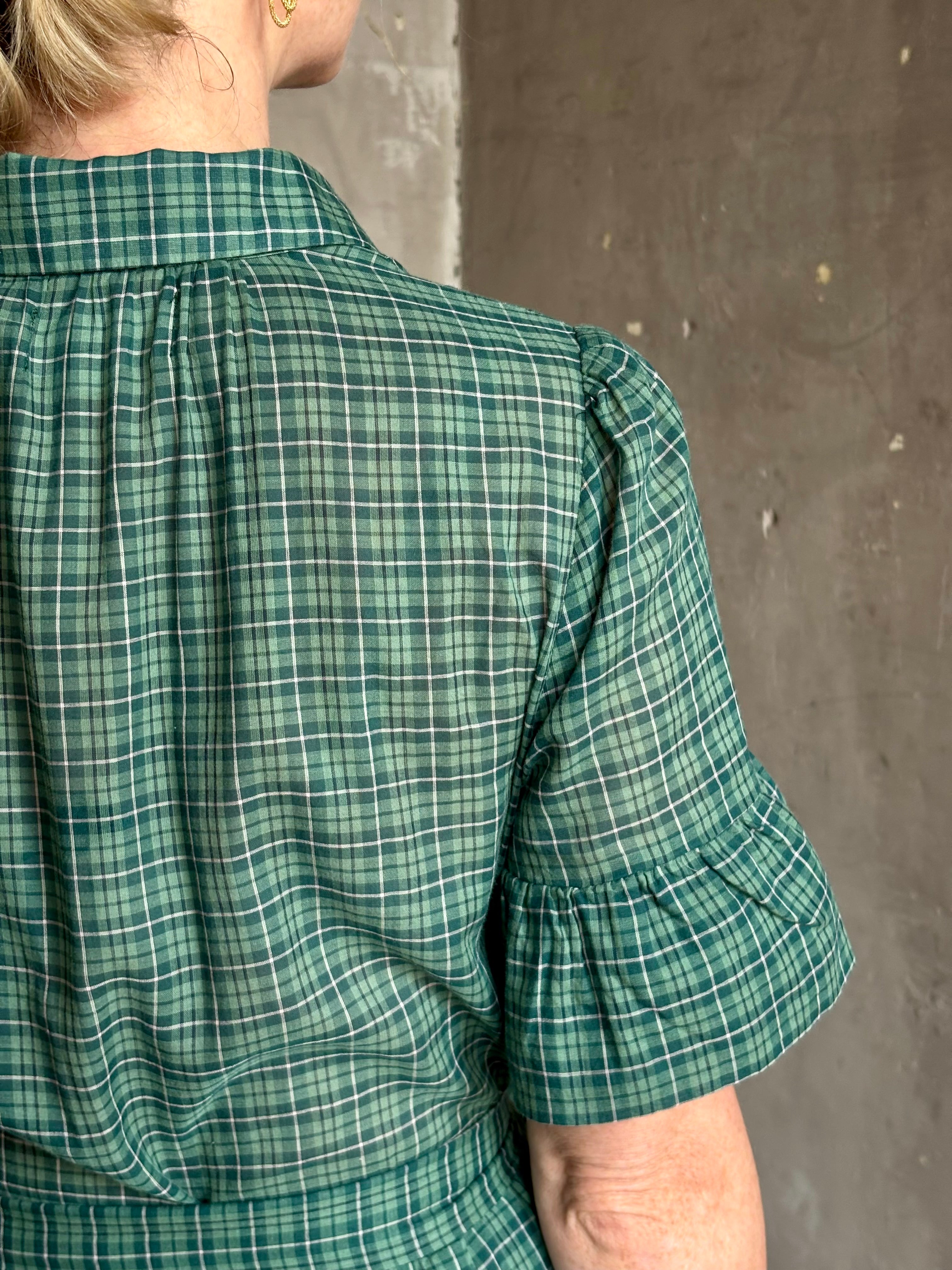 Mature woman wearing Trovata Martine button-up front cotton poplin green plaid maxi dress short sleeves and lightweight