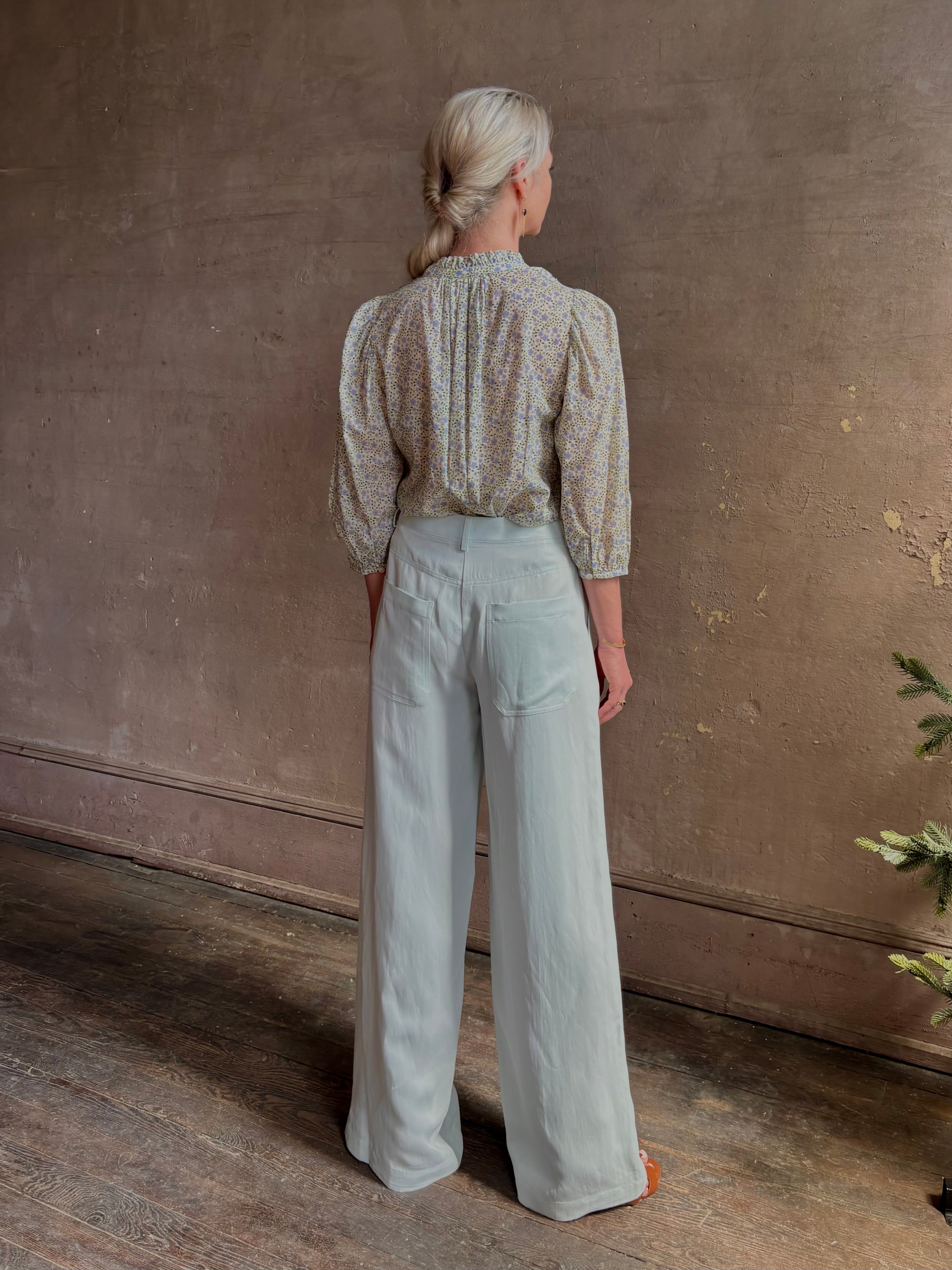 Mature woman wearing the Orly blouse from Trovata rendered in a charming coastal inspired floral print and crafted from cotton with three quarter sleeves and ruffle lined v-neck