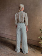 Mature woman wearing the Orly blouse from Trovata rendered in a charming coastal inspired floral print and crafted from cotton with three quarter sleeves and ruffle lined v-neck