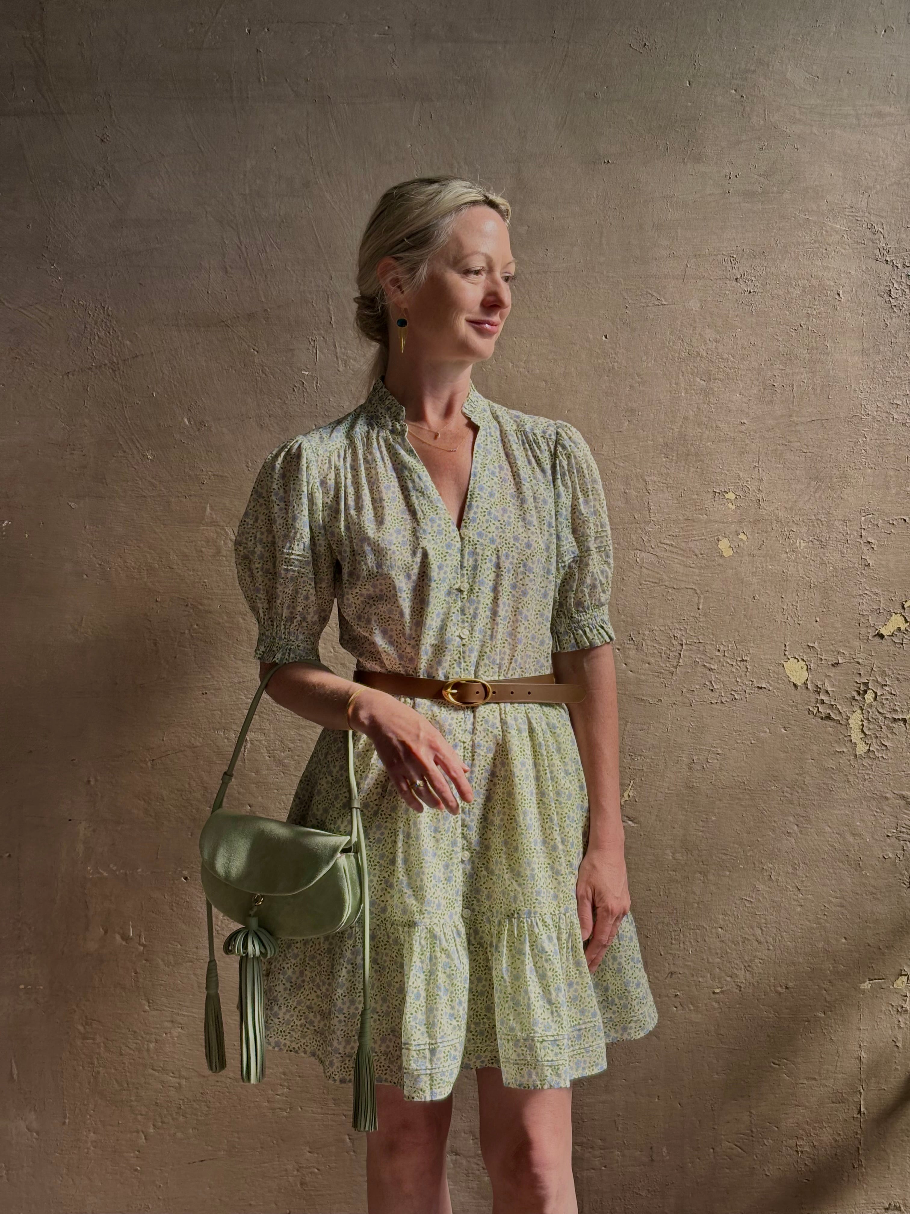 Mature woman wearing the short Phoebe Dress from Trovata rendered in a charming coastal inspired floral print and crafted from cotton with button front, ruffle lined short sleeves and v-neck