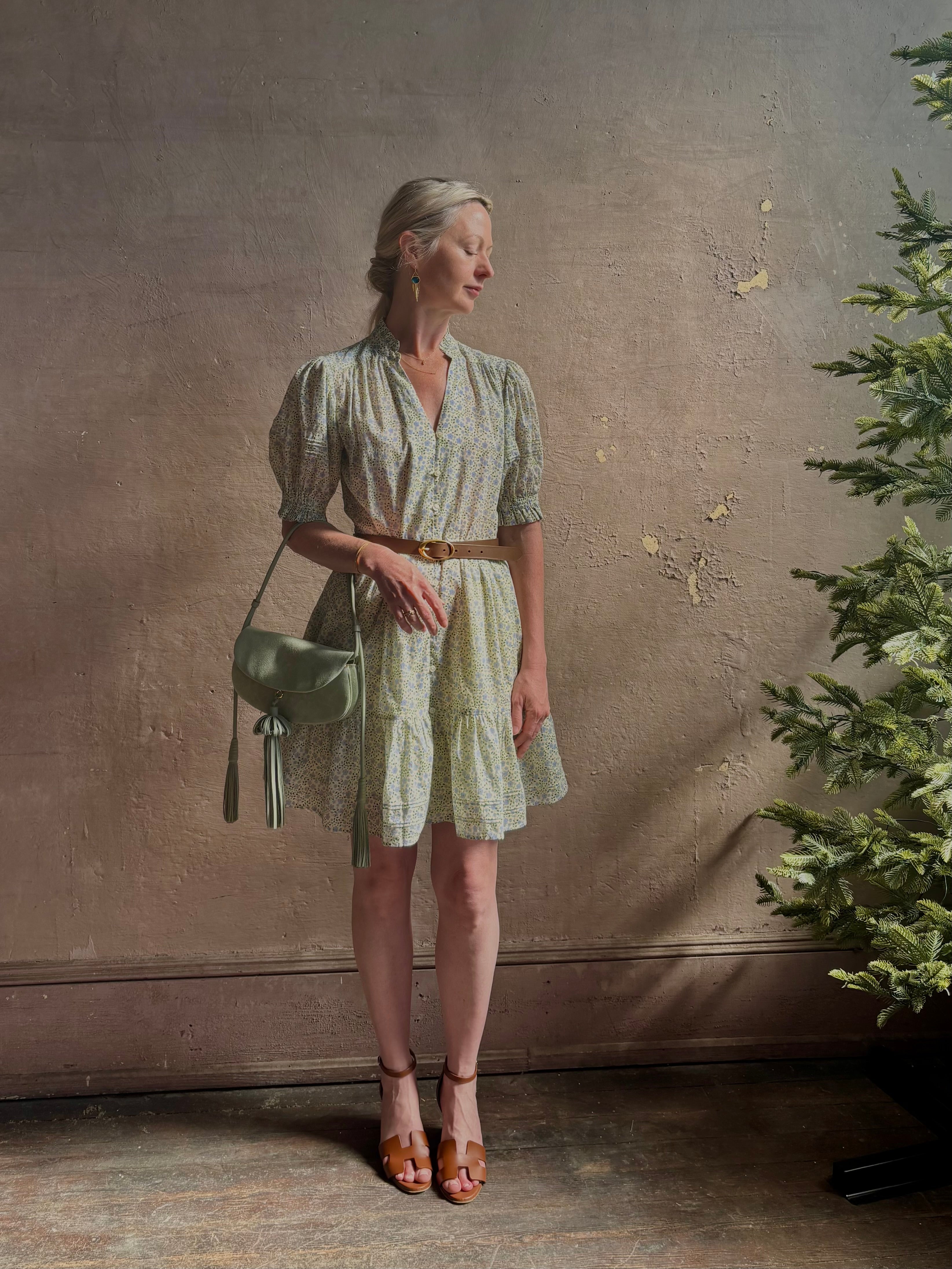Mature woman wearing the short Phoebe Dress from Trovata rendered in a charming coastal inspired floral print and crafted from cotton with button front, ruffle lined short sleeves and v-neck