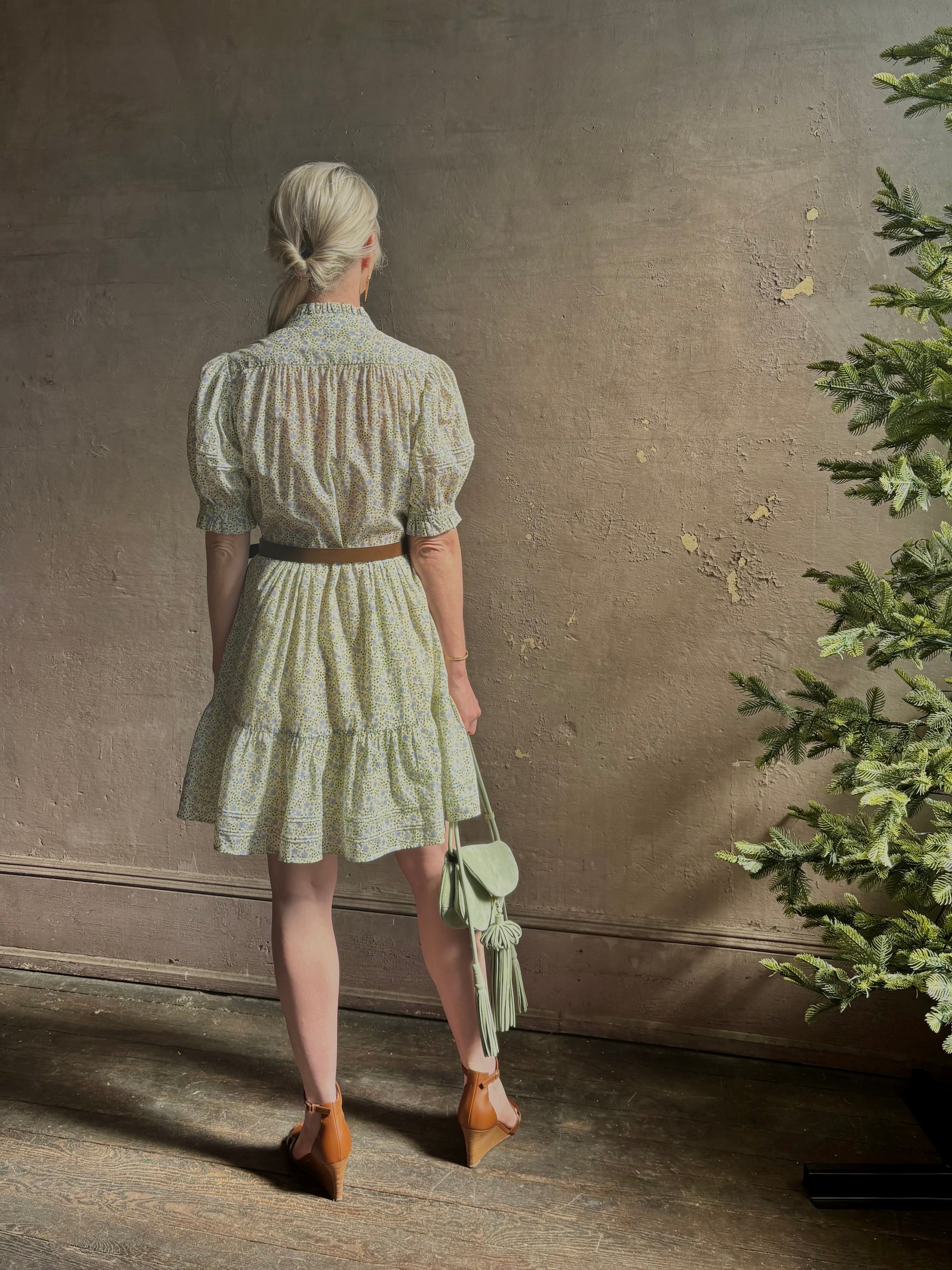 Mature woman wearing the short Phoebe Dress from Trovata rendered in a charming coastal inspired floral print and crafted from cotton with button front, ruffle lined short sleeves and v-neck