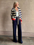 Mature woman wearing comfy cotton Rafa zip up hoodie by Trovata in a classic navy and white stripe with an elevated gold tone zipper.