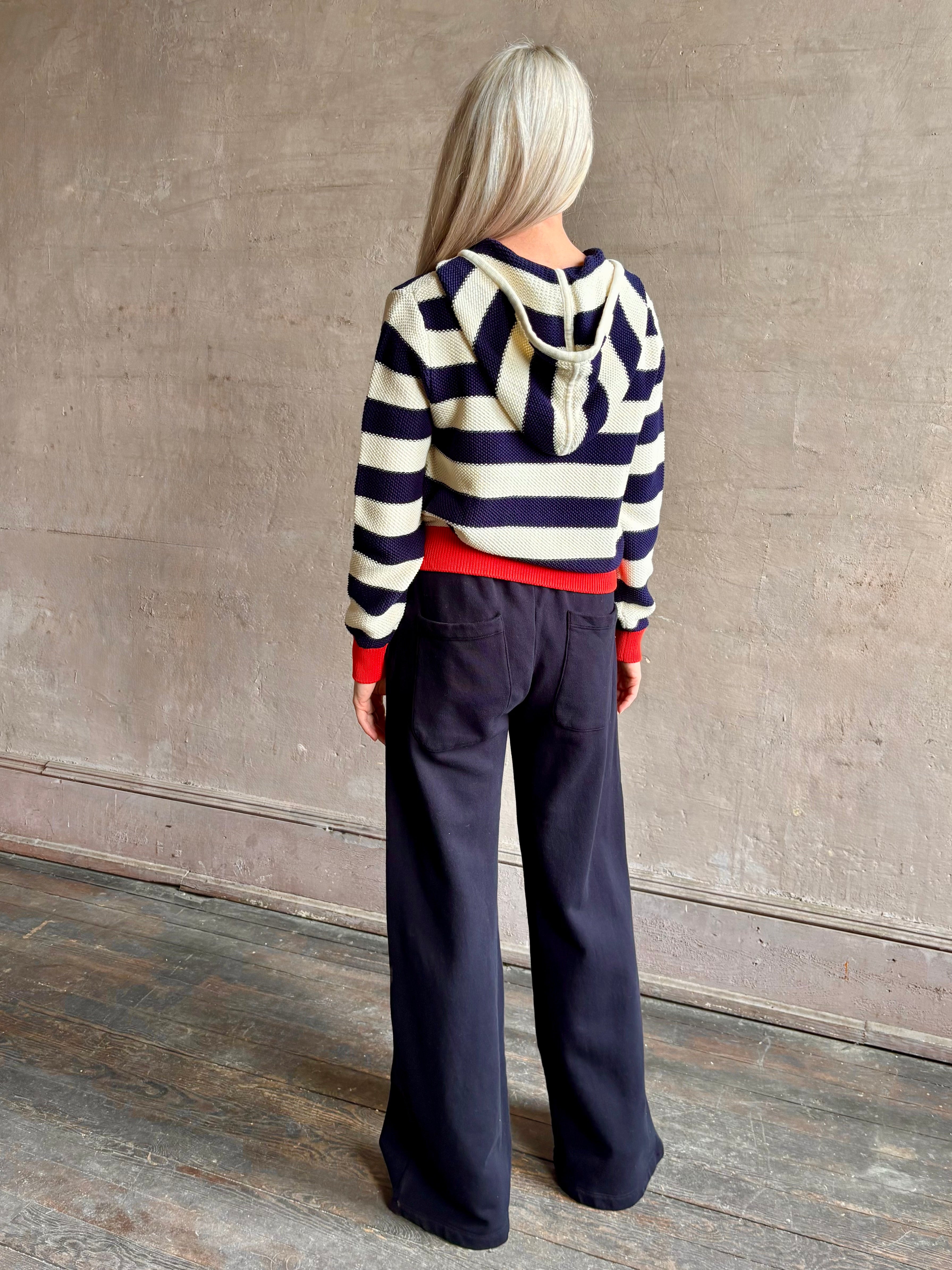 Mature woman wearing comfy cotton Rafa zip up hoodie by Trovata in a classic navy and white stripe with an elevated gold tone zipper.