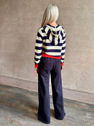 Mature woman wearing comfy cotton Rafa zip up hoodie by Trovata in a classic navy and white stripe with an elevated gold tone zipper.