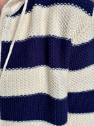 Mature woman wearing comfy cotton Rafa zip up hoodie by Trovata in a classic navy and white stripe with an elevated gold tone zipper.