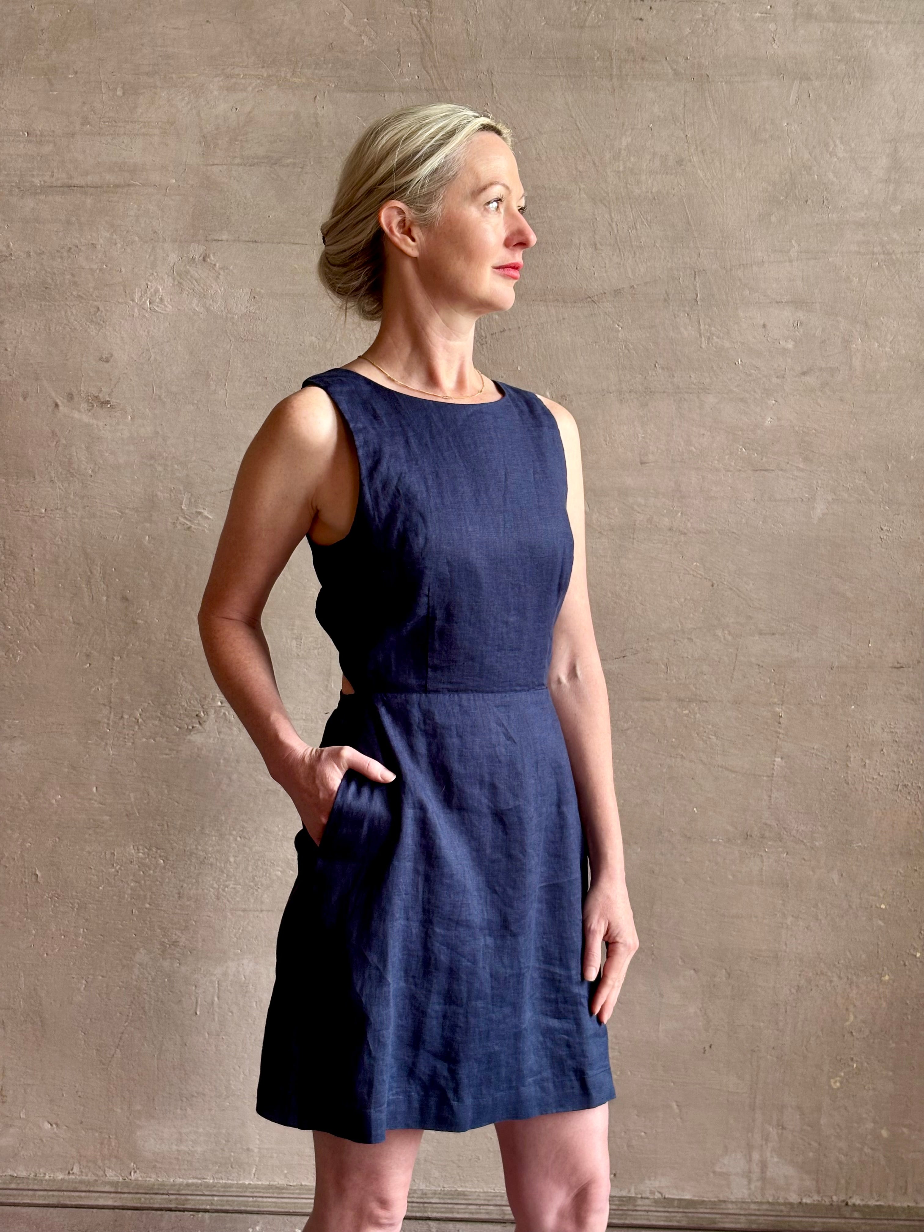 Woman wearing the effortless summer dress by Trovata Rosalie linen Dress in Navy Blue with A-line skirt and sophisticated bra friendly open back