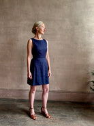 Woman wearing the effortless summer dress by Trovata Rosalie linen Dress in Navy Blue with A-line skirt and sophisticated bra friendly open back