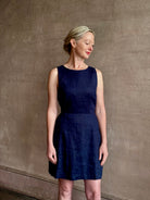 Woman wearing the effortless summer dress by Trovata Rosalie linen Dress in Navy Blue with A-line skirt and sophisticated bra friendly open back