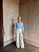 Mature woman wearing blue and cream vertically striped long-sleeve cotton Trovata Rumi button front shirt