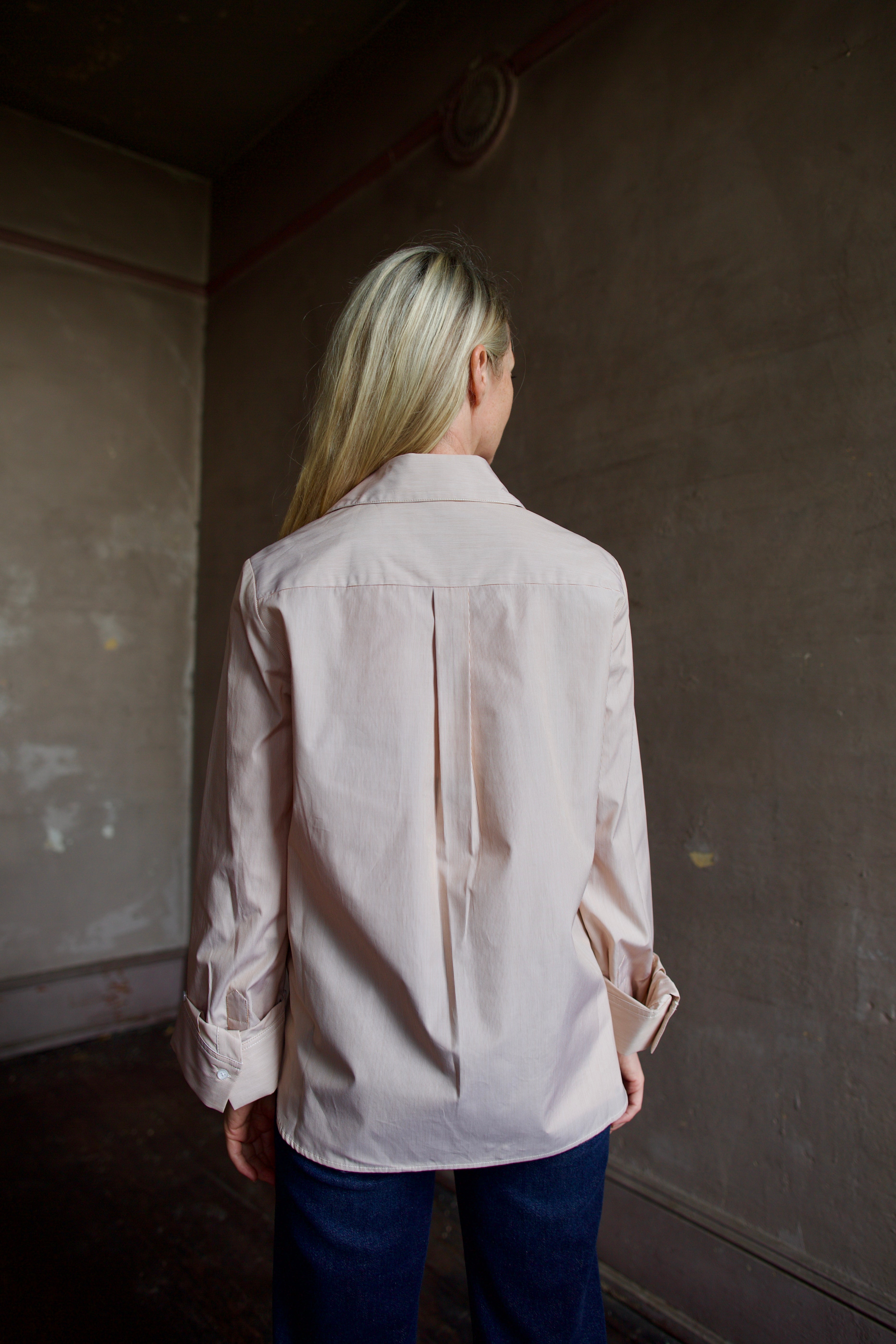 Back of model wearing striped TWP button down boyfriend shirt and denim
