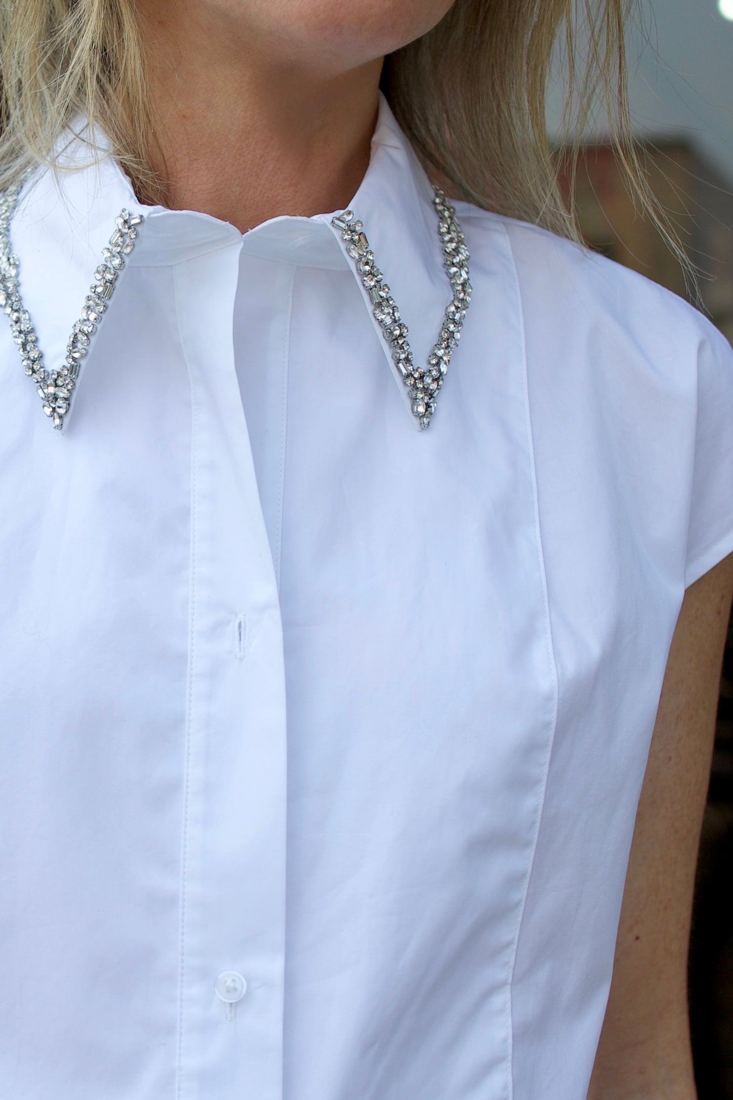 Mature model wearing luxury brand TWP white cap sleeve top with detachable crystal beaded collar in premium cotton 