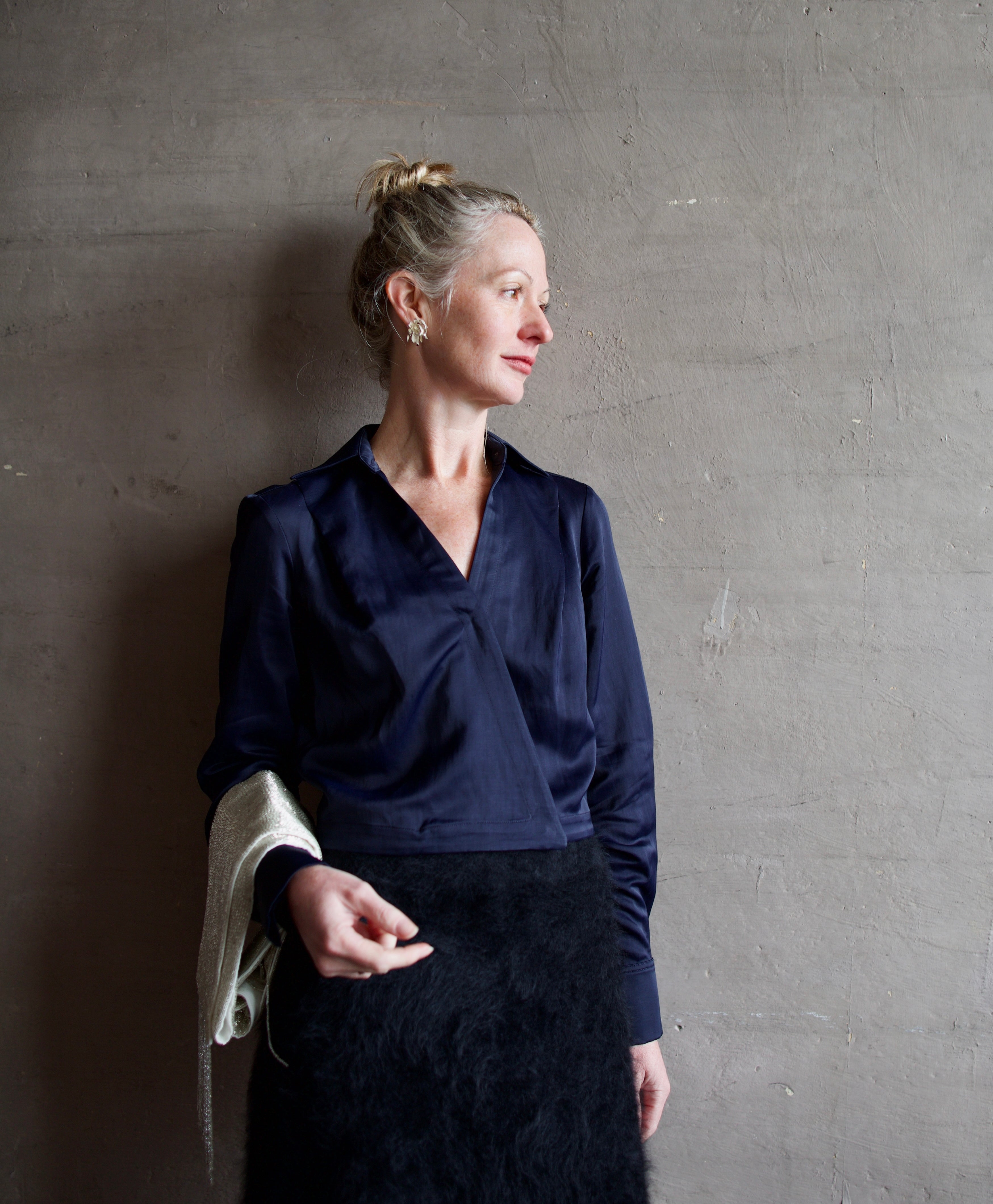 image of a woman wearing the TWP GT Goan blouse with the Lisa Yang brushed cashmere skirt, Anna Johnson depleted silver earrings and TWP beaded scarf