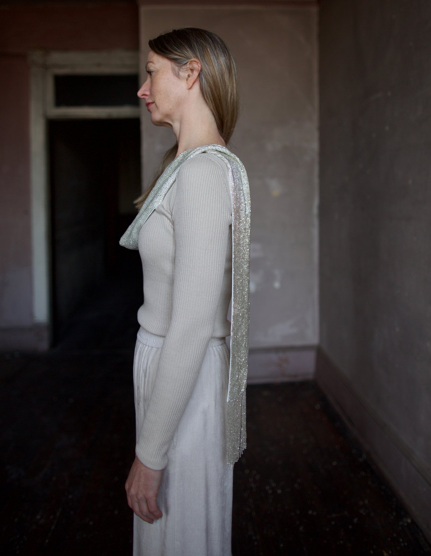 image of the side of a woman wearing the TWP ribbed top and beaded scarf