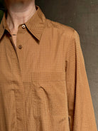 Mature woman wearing sophisticated TWP Jennys shirt dress embellished with crystals in warm brown