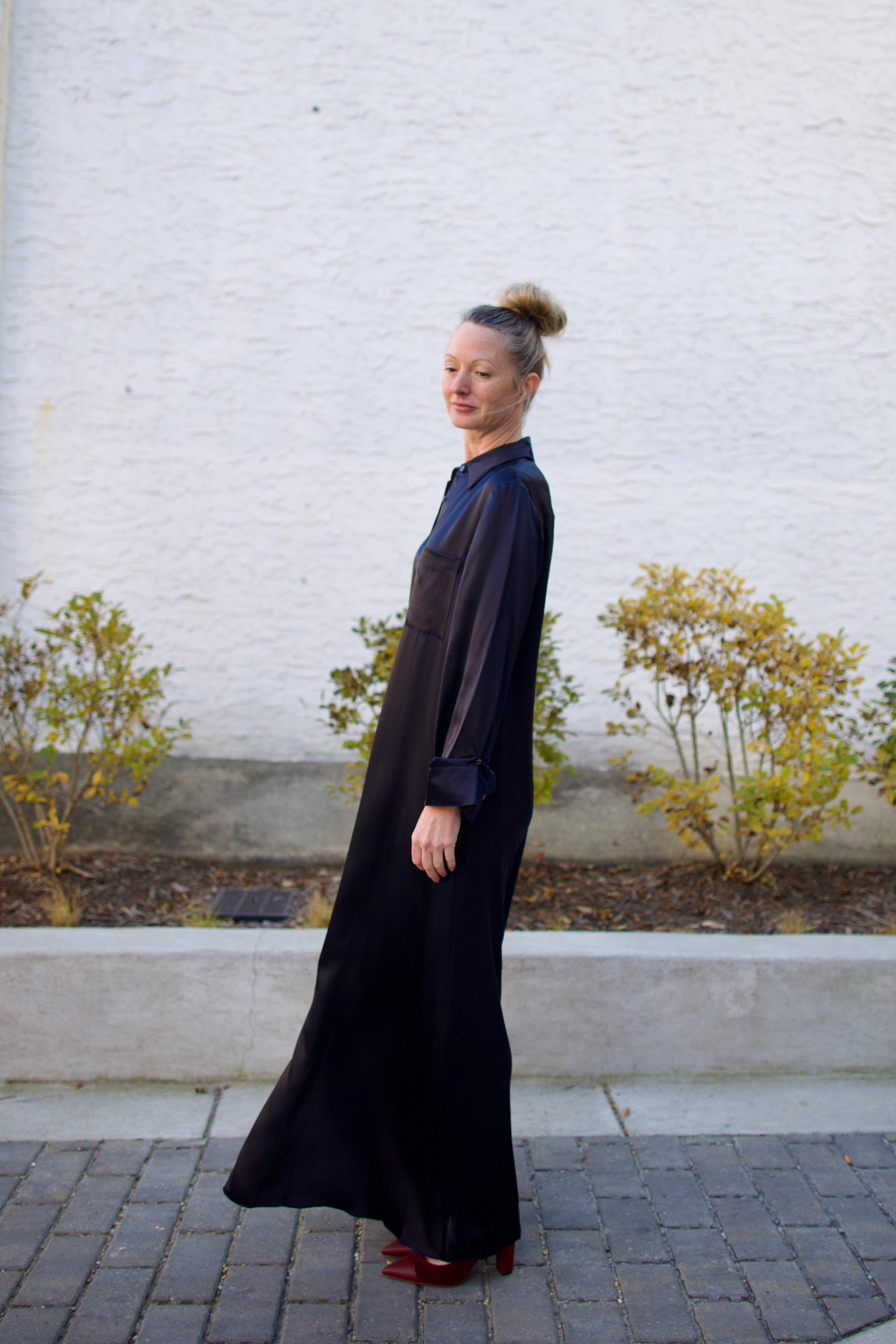 Image featuring a woman modeling the TWP Jennys oversized maxi shirt dress in sleek navy blue silk charmeuse.