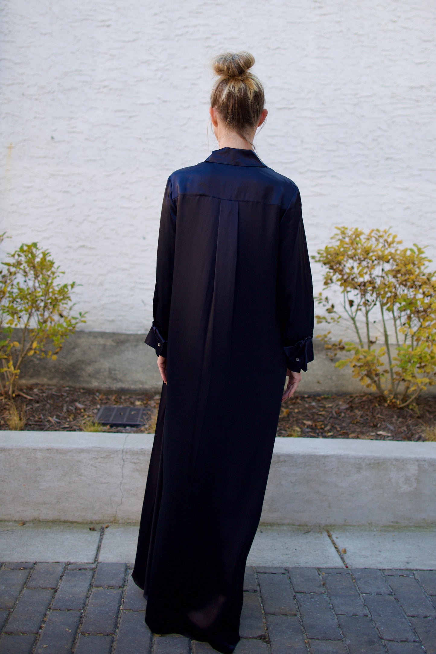 Image featuring a woman modeling the TWP Jennys oversized maxi shirt dress in sleek navy blue silk charmeuse.