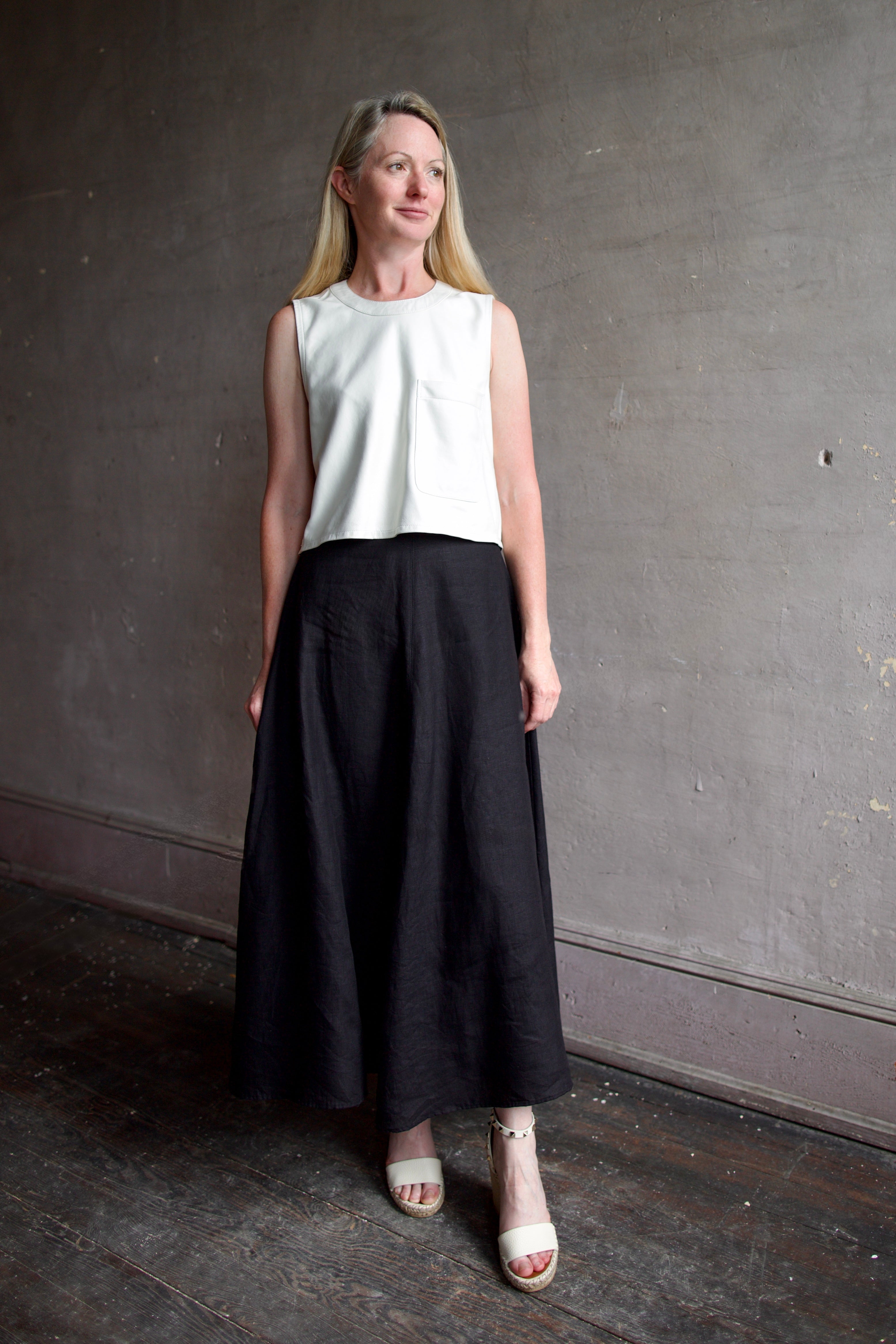 Image of model wearing luxury contemporary TWP lamb skin Leather Top and a black linen Apiece Apart Primavera Skirt