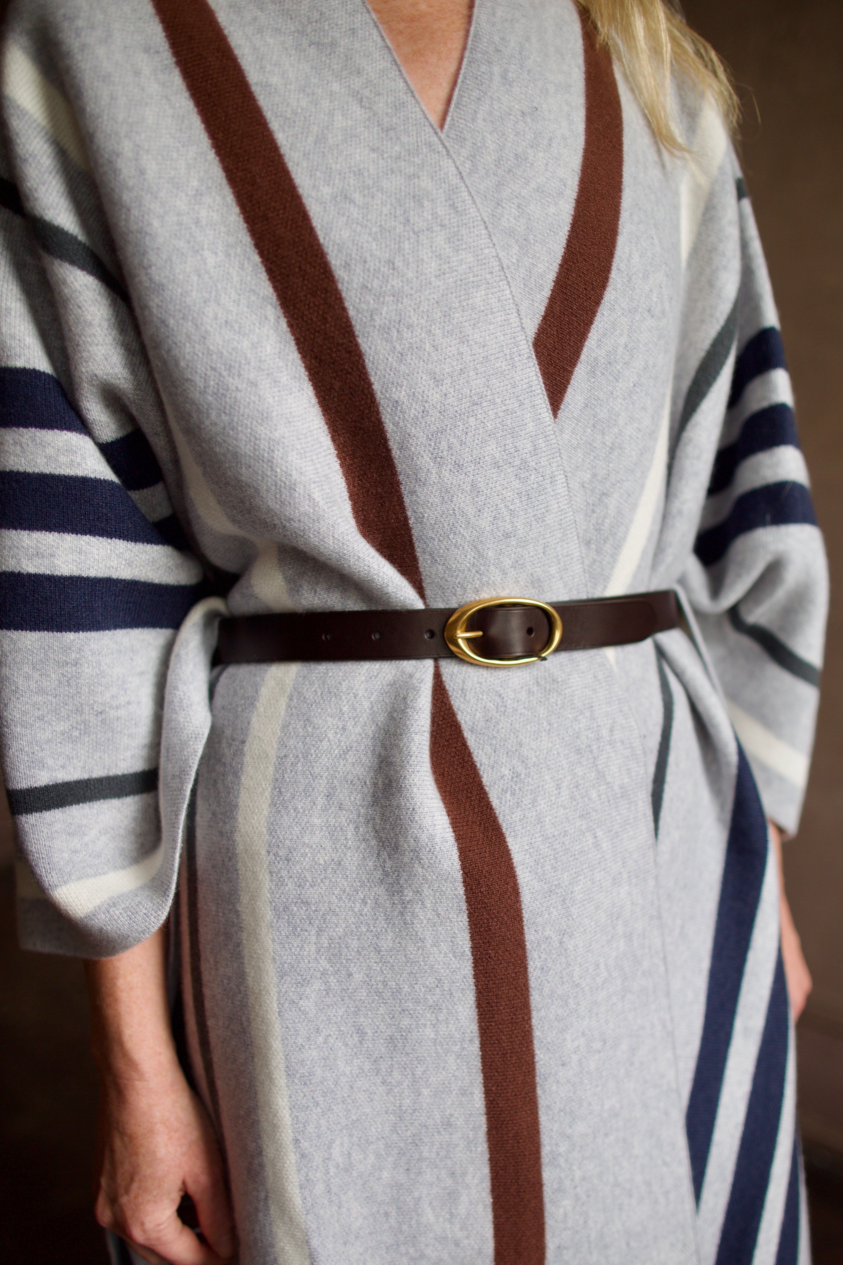 Mature Model wearing gray TWP luxury Italian cashmere with brown and navy stripes and a leather belt