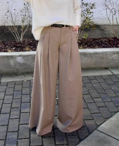 Image of a woman wearing the TWP new didi pants in sandstone, the Ulla Johnson gia belt, and the Lisa Yang Margareta sweater.