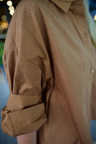 Close up detail of model wearing a TWP shirt embellished with crystals in a warm brown 