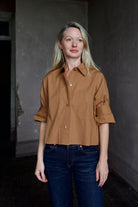 Mature model wearing the epitome of casual chic in a brown TWP shirt embellished with crystals and dark denim