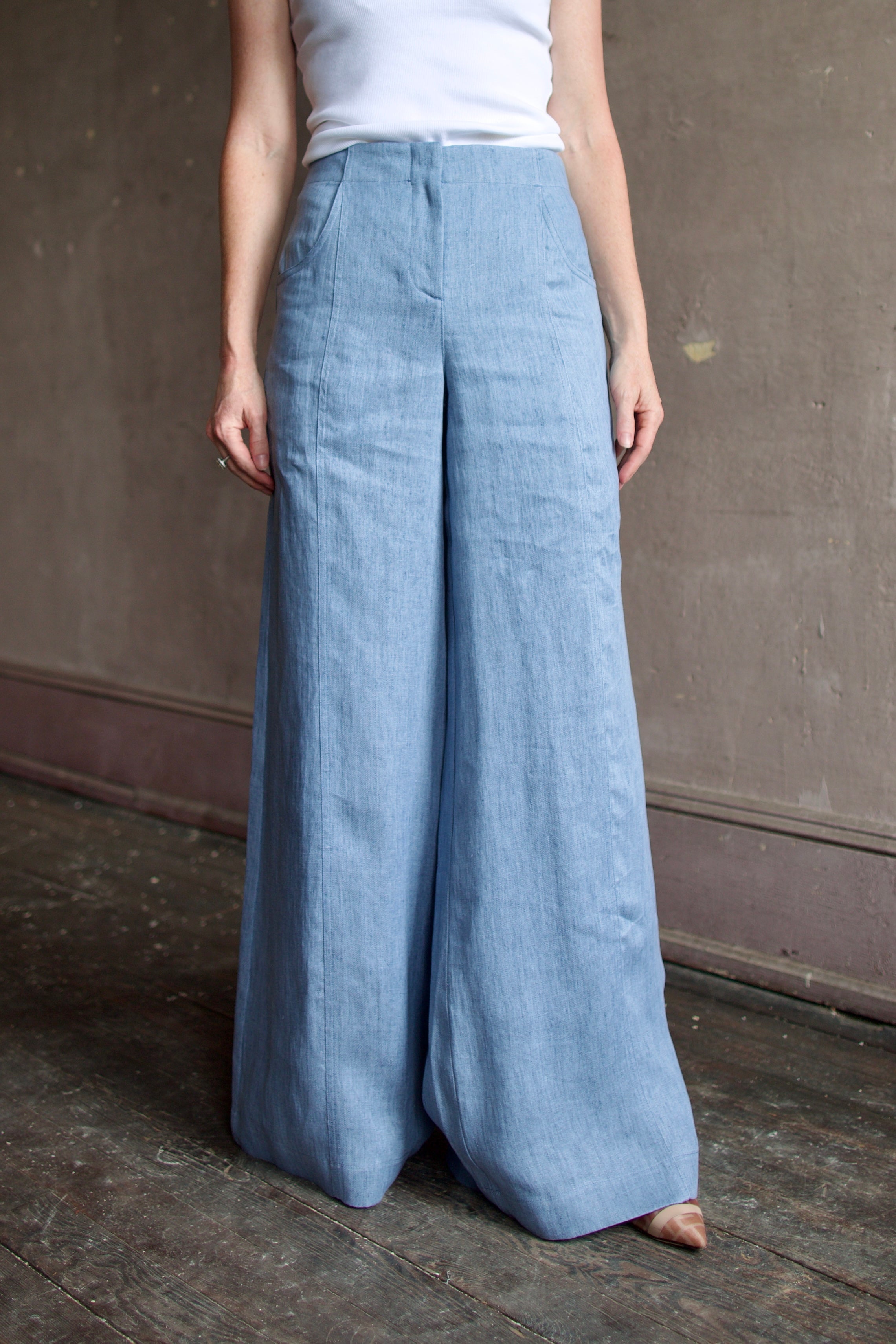 Mature woman wearing luxury brand TWP Demie High Rise wide leg indigo hemp Pants offers timeless  refinement and expert craftsmanship