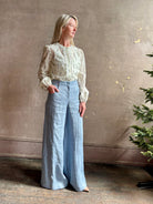 Mature woman wearing luxury brand TWP Demie High Rise wide leg indigo hemp Pants offers timeless  refinement and expert craftsmanship