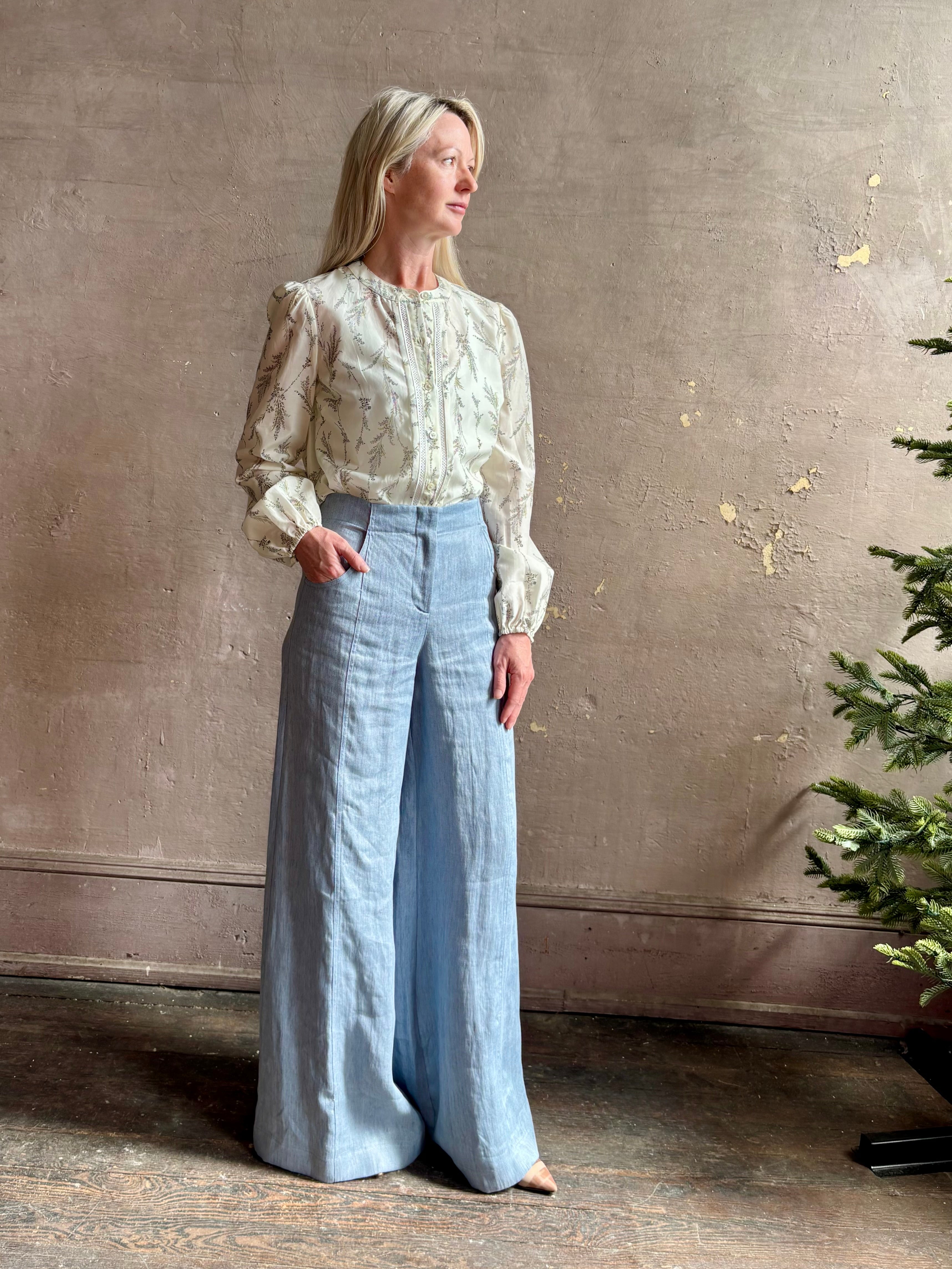 Mature woman wearing luxury brand TWP Demie High Rise wide leg indigo hemp Pants offers timeless  refinement and expert craftsmanship