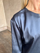 Image of mature woman wearing TWP Ex T in premium hammered satin with short sleeve crew neck and a casual front pocket