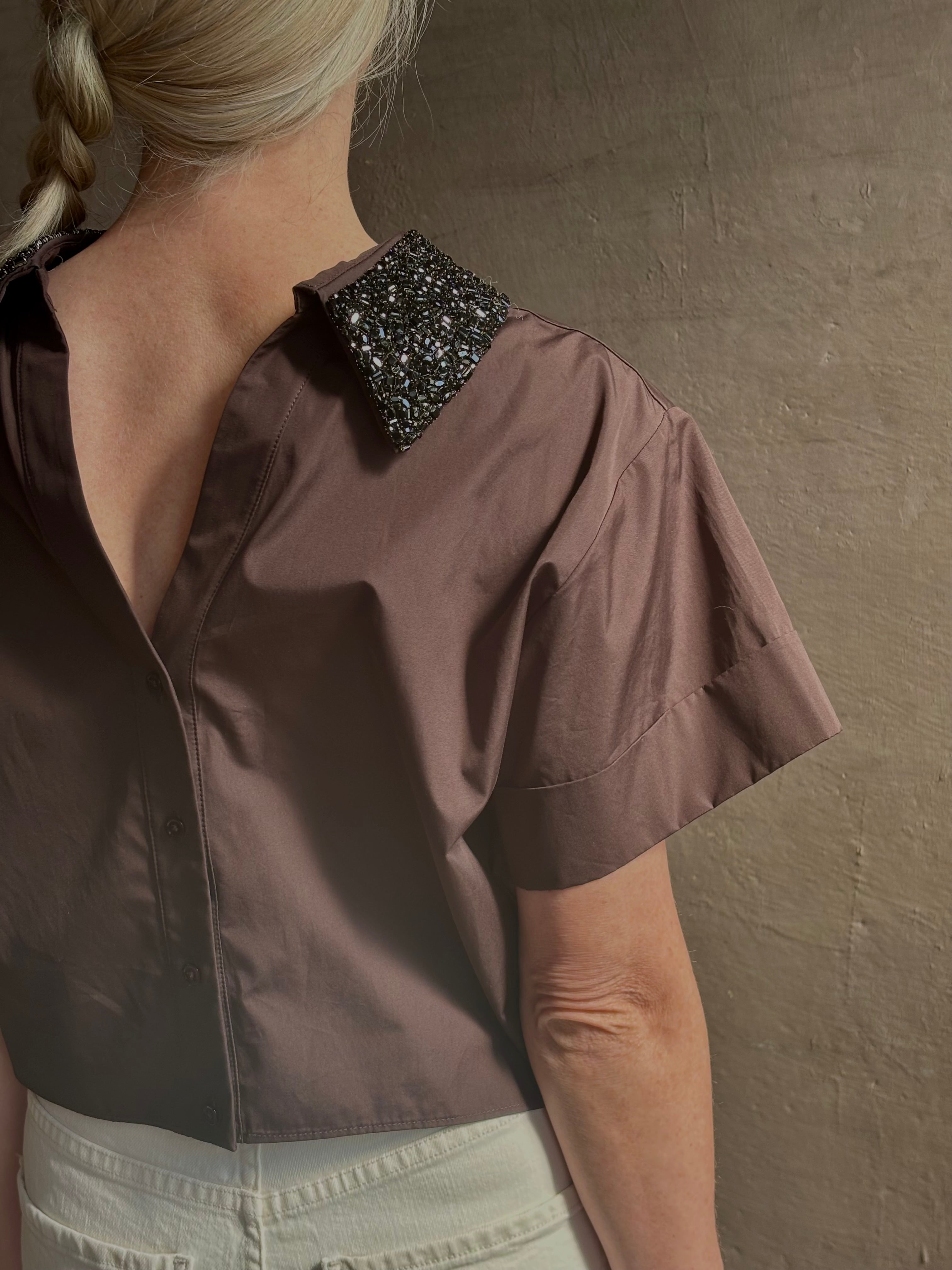 Mature woman wearing Forever and Always with Crystal Collar Top from TWP women's luxury designer blouse rendered in chocolate brown and crafted from 100% cotton in the USA with crystal collar, short sleeves and reversible