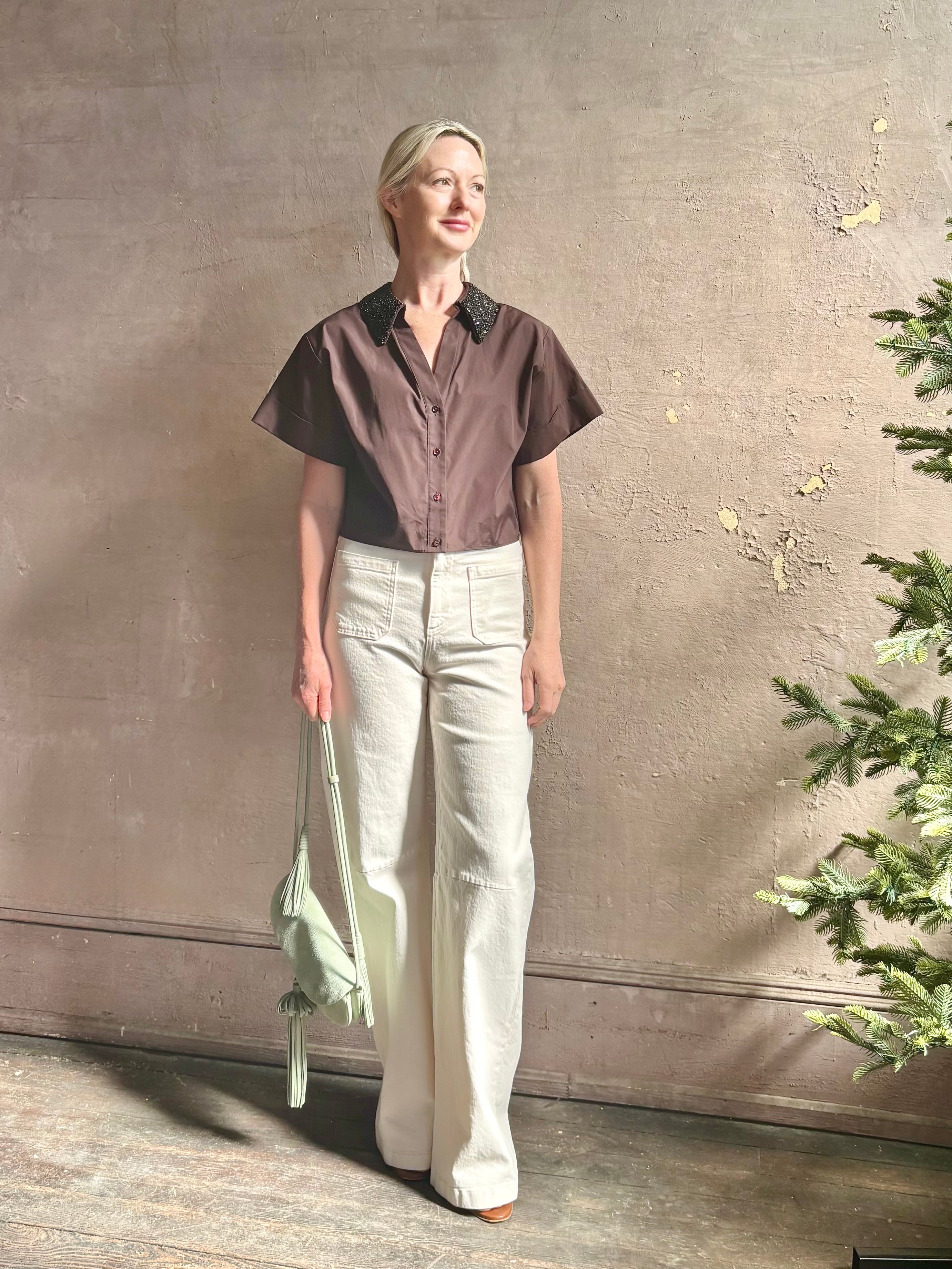 Mature woman wearing Forever and Always with Crystal Collar Top from TWP women's luxury designer blouse rendered in chocolate brown and crafted from 100% cotton in the USA with crystal collar, short sleeves and reversible