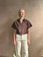 Mature woman wearing Forever and Always with Crystal Collar Top from TWP women's luxury designer blouse rendered in chocolate brown and crafted from 100% cotton in the USA with crystal collar, short sleeves and reversible