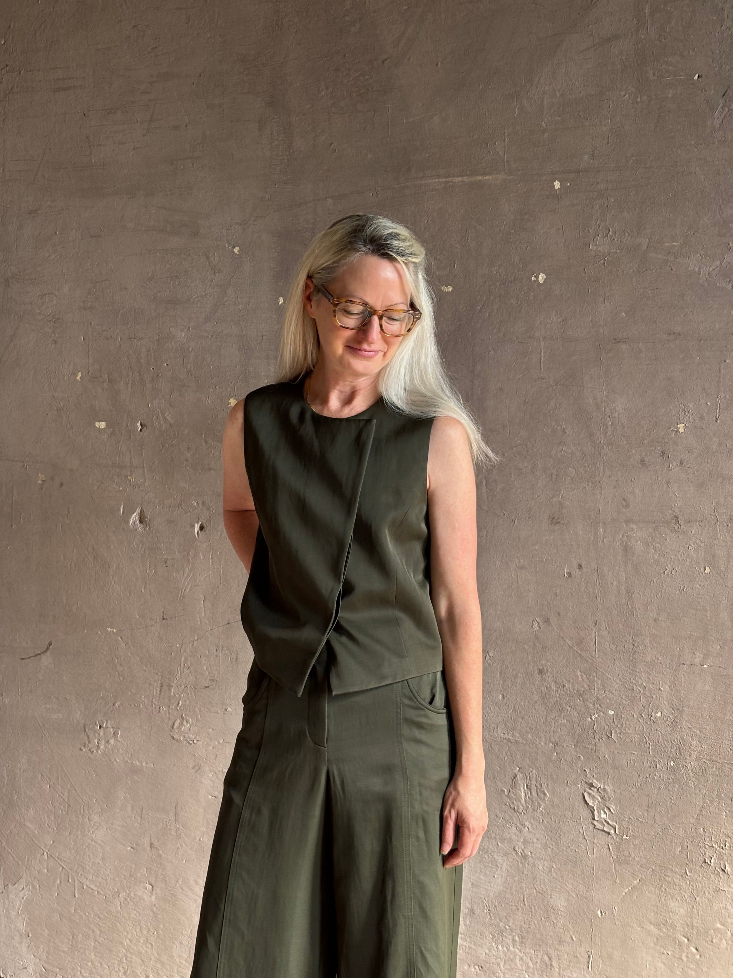 Luxury women's clothing brand TWP high neck hidden placket vest top with matching pant set in a green linen blend