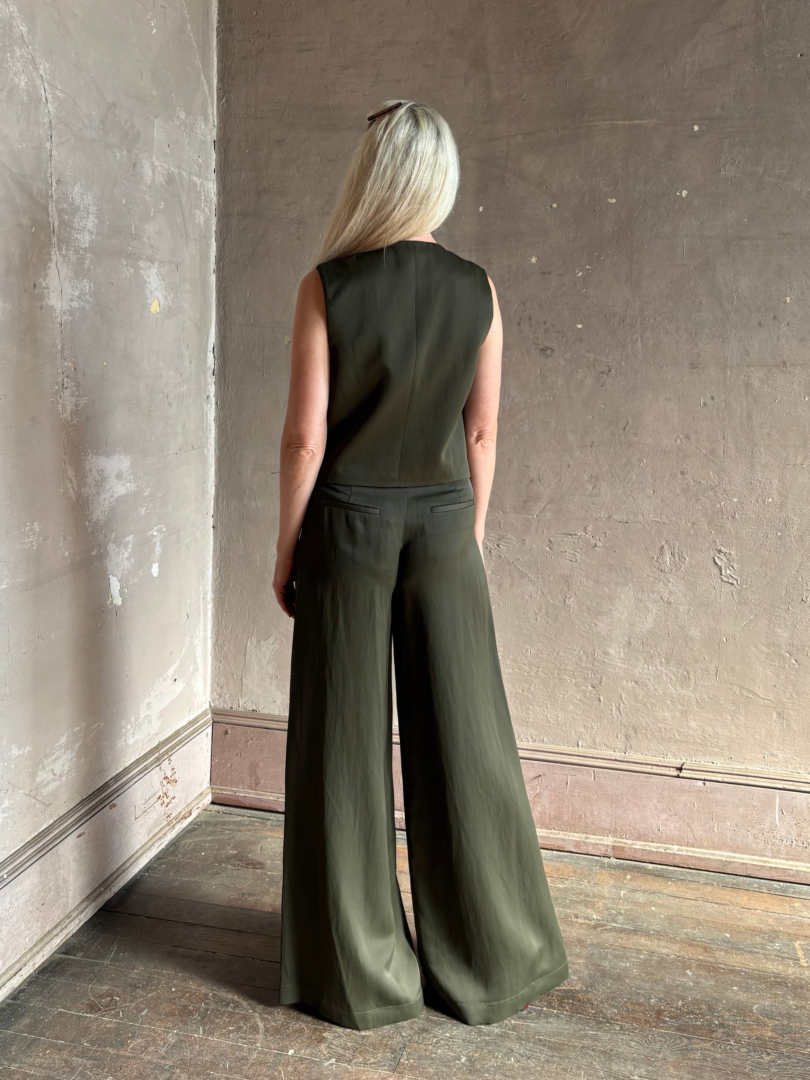 Luxury women's clothing brand TWP high neck hidden placket vest top with matching pant set in a green linen blend