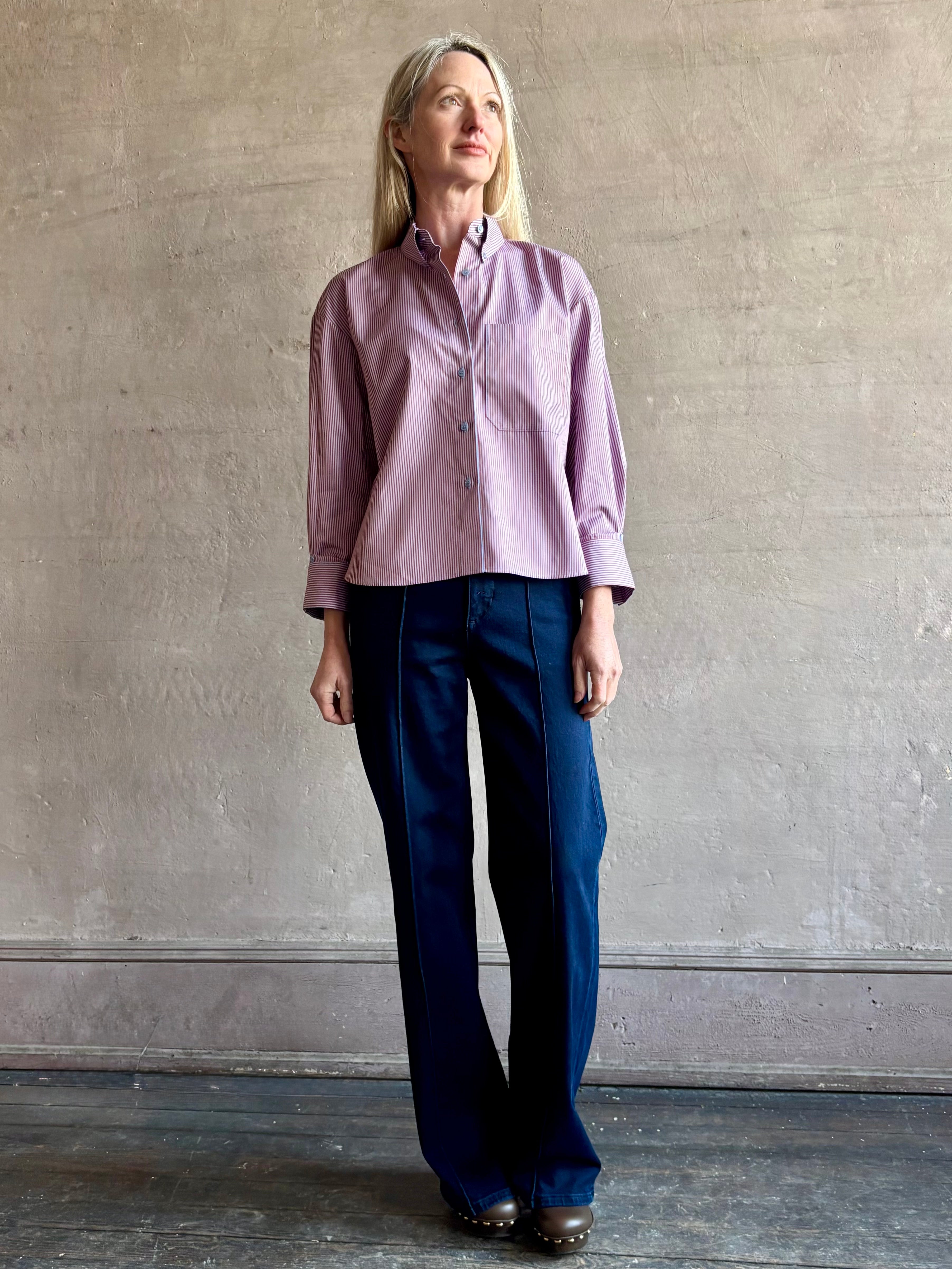 Woman wearing premium cotton poplin JD menswear inspired shirt from TWP in a rust and blue stripe with long sleeve and collar