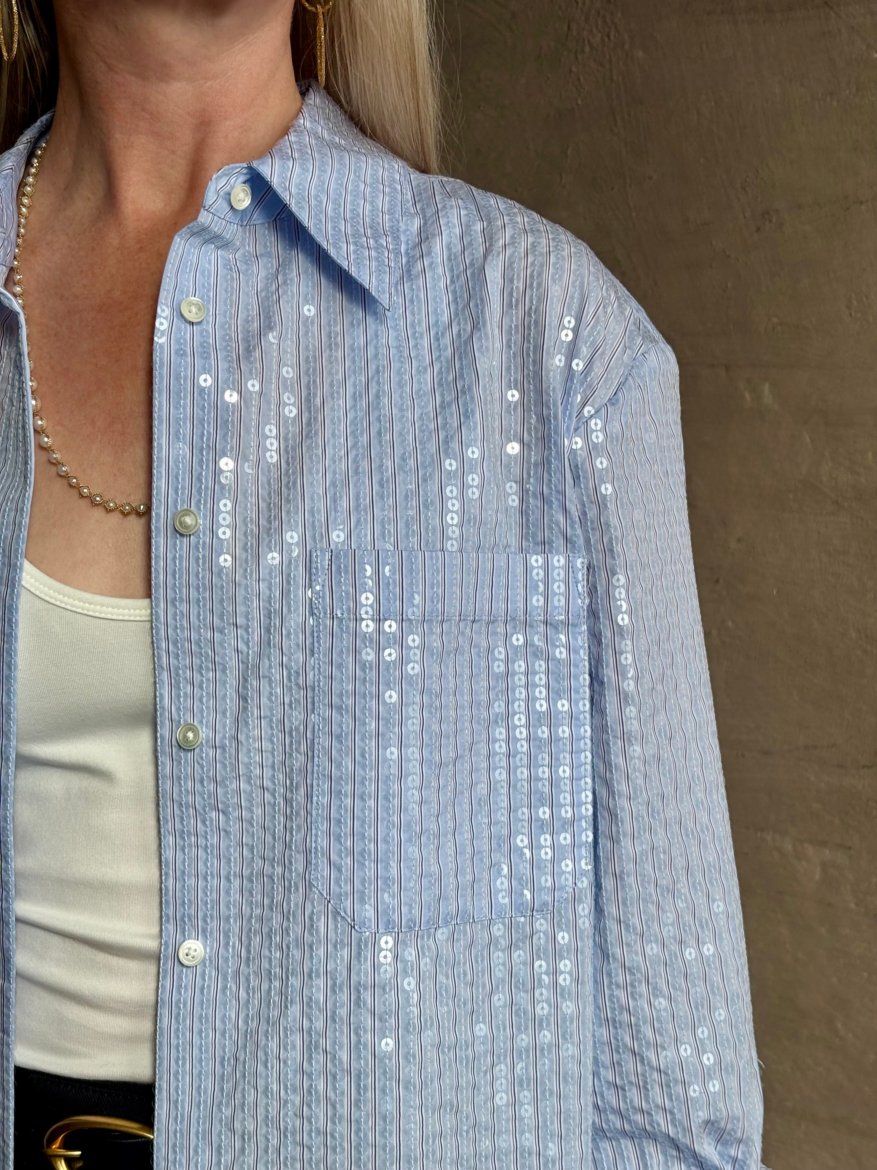 Mature woman wearing JD blue and white stripe collared button-down shirt by TWP with sequin embellishments