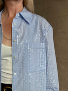 Mature woman wearing JD blue and white stripe collared button-down shirt by TWP with sequin embellishments