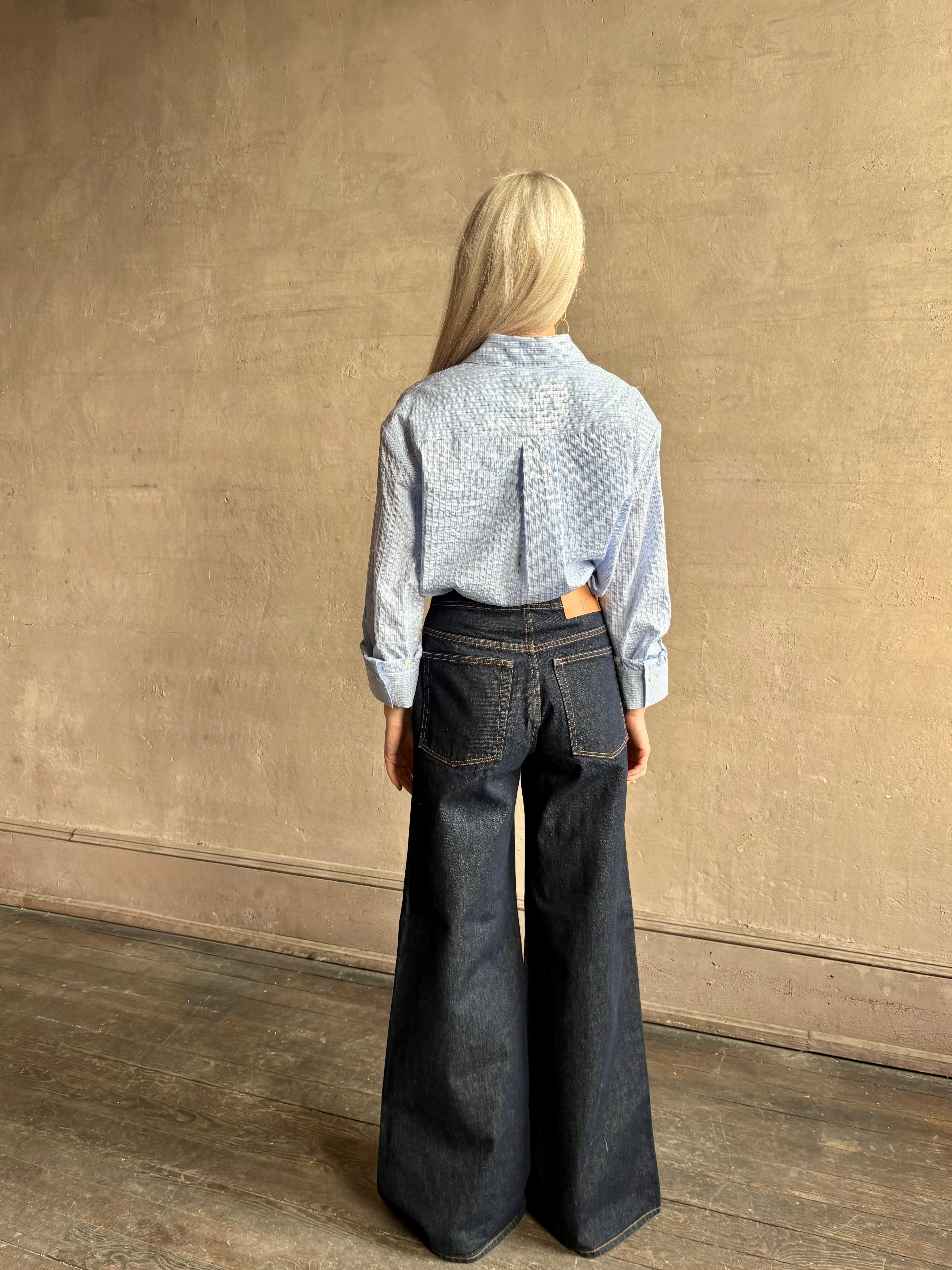 Mature woman wearing JD blue and white stripe collared button-down shirt by TWP with sequin embellishments