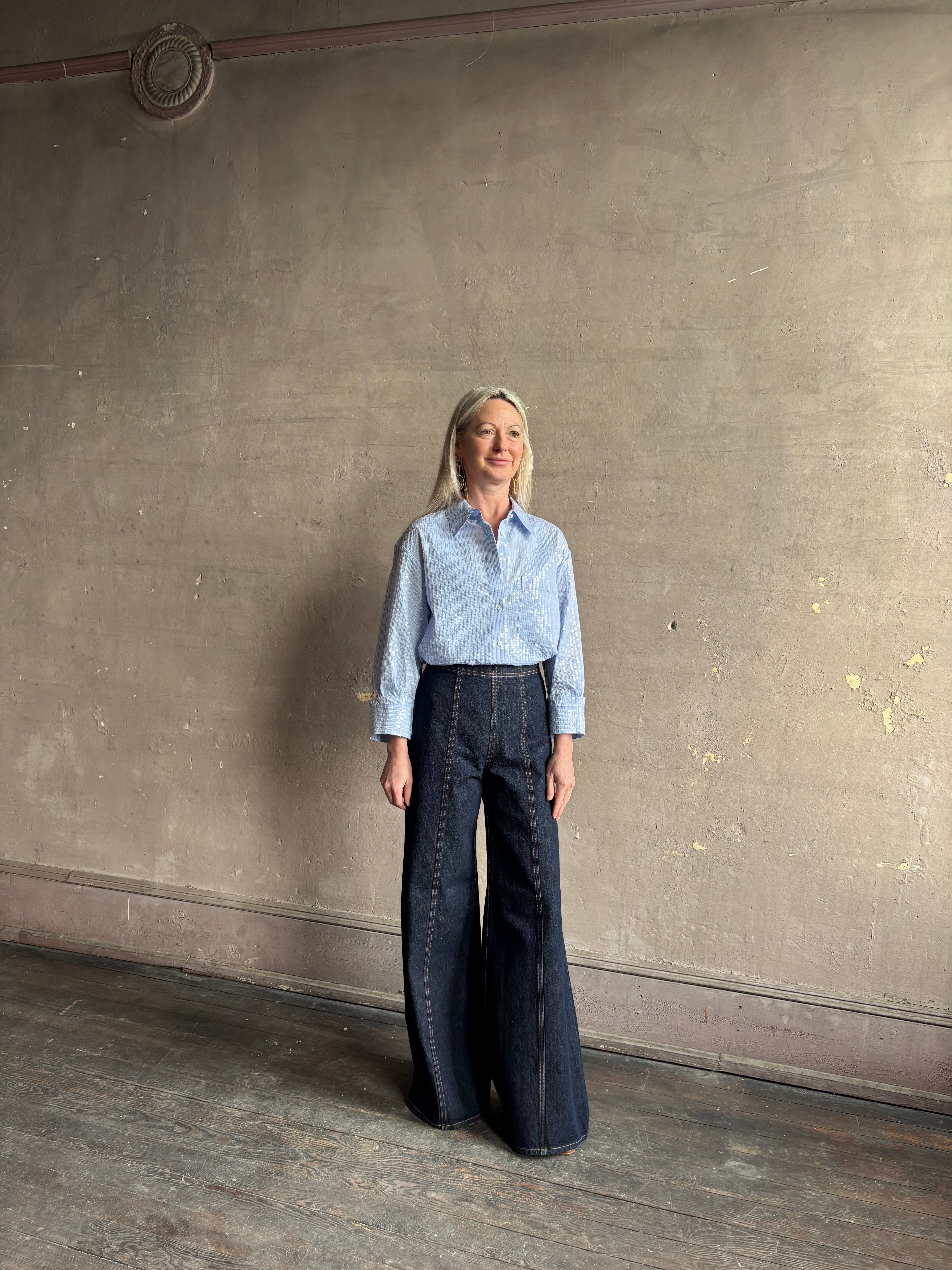 Mature woman wearing JD blue and white stripe collared button-down shirt by TWP with sequin embellishments