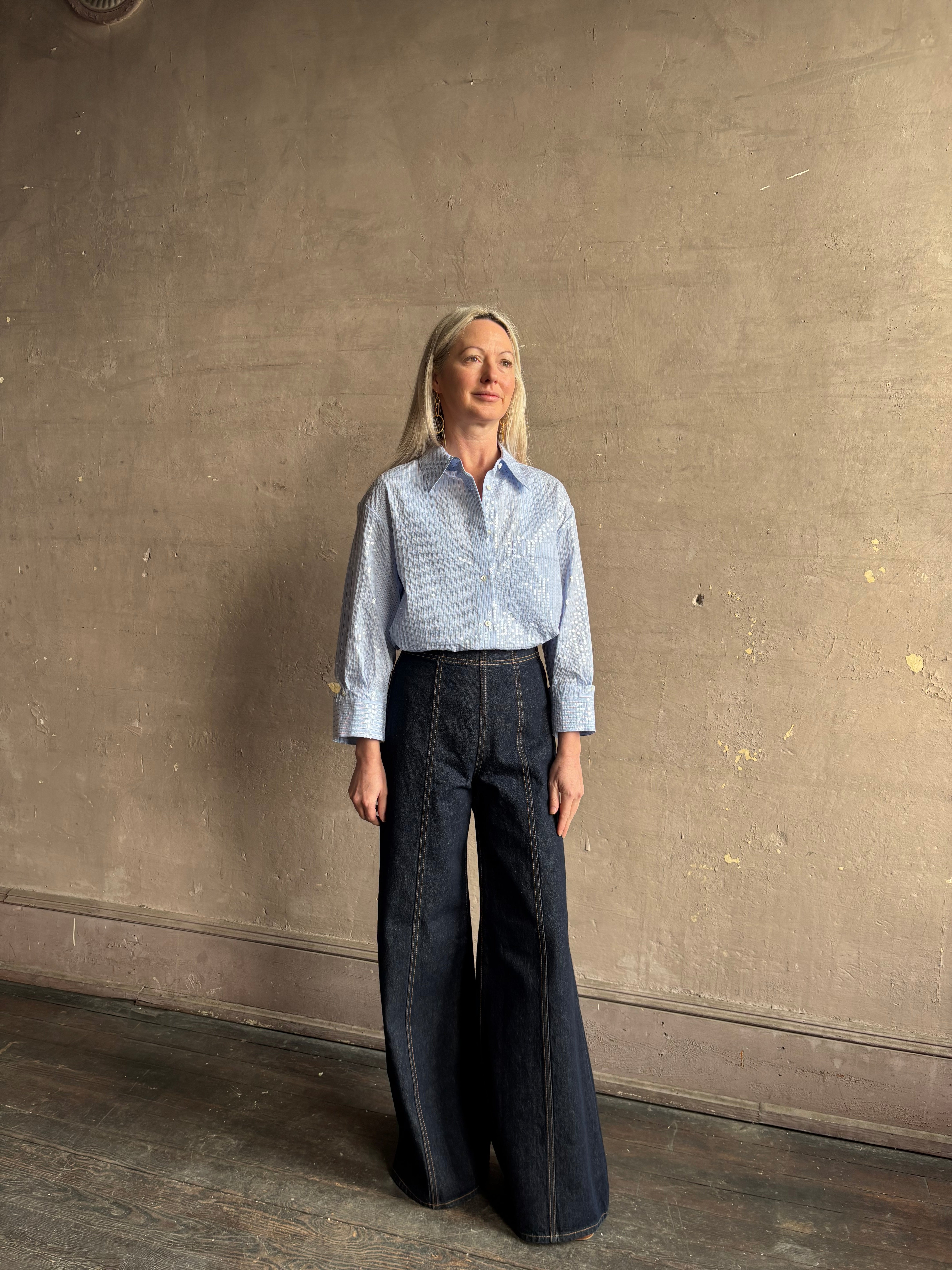 Mature woman wearing JD blue and white stripe collared button-down shirt by TWP with sequin embellishments
