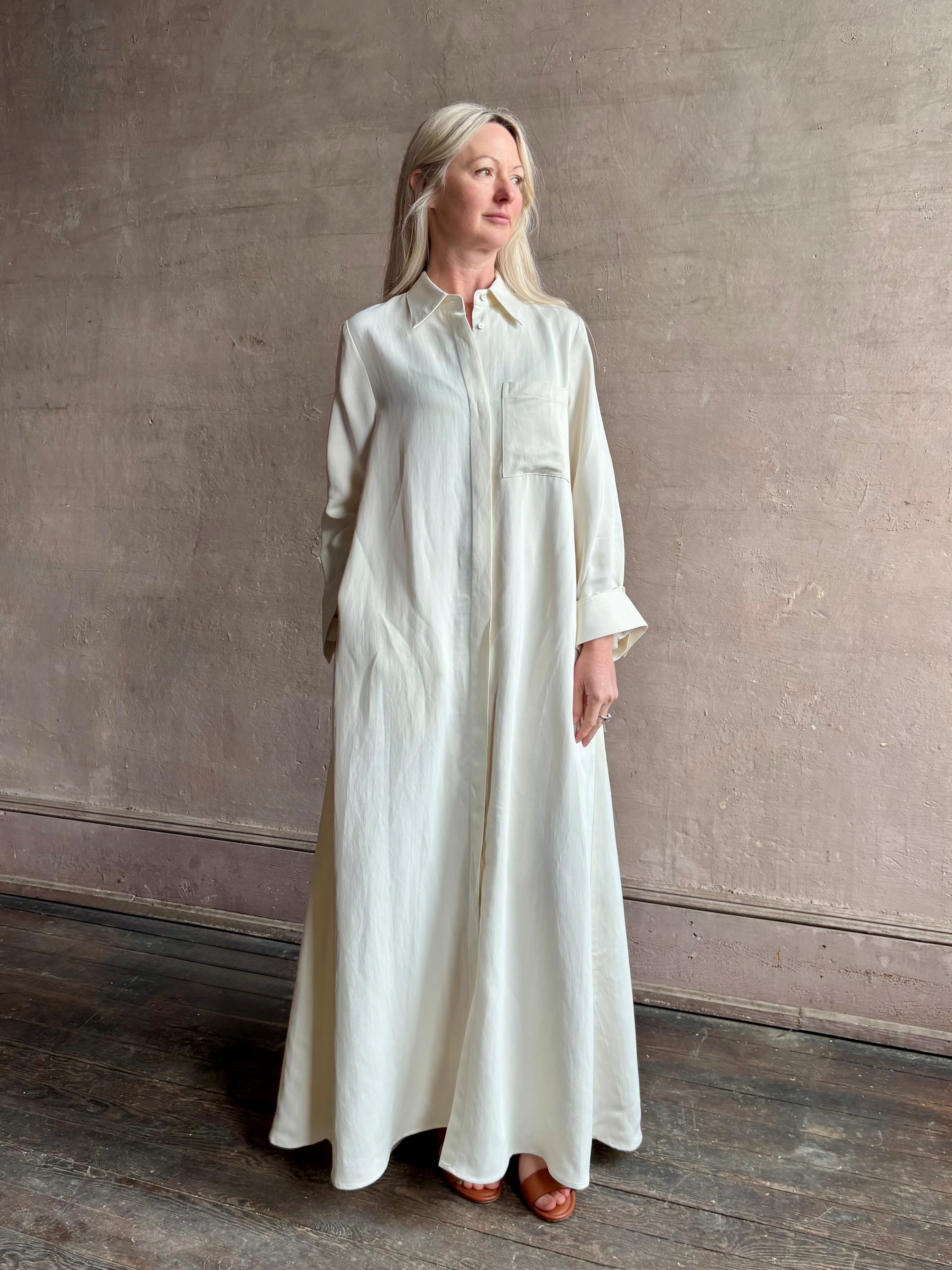 Mature Woman wearing Jenny's Gown from TWP is a women's designer floor length gown rendered in a soft bone hue crafted from a luxurious blend of viscose and linen