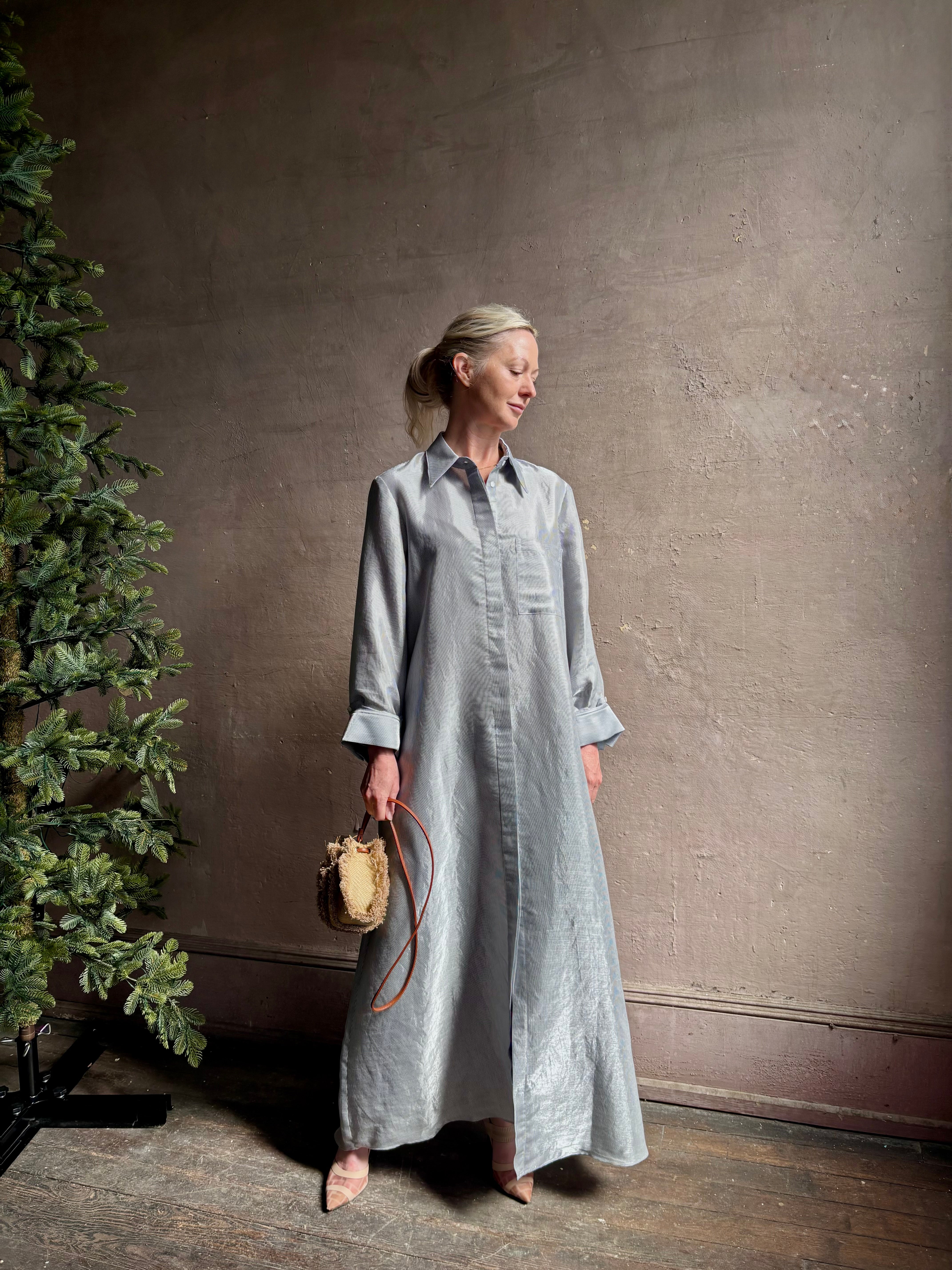 Mature woman wearing luxury Jenny's Gown from designer TWP rendered in a lumines white and blue stripe print and crafted in USA from a viscose and lorex blend this lightweight long sleeve maxi  dress drapes beautifully with a flowing quality that moves with understated grace 
