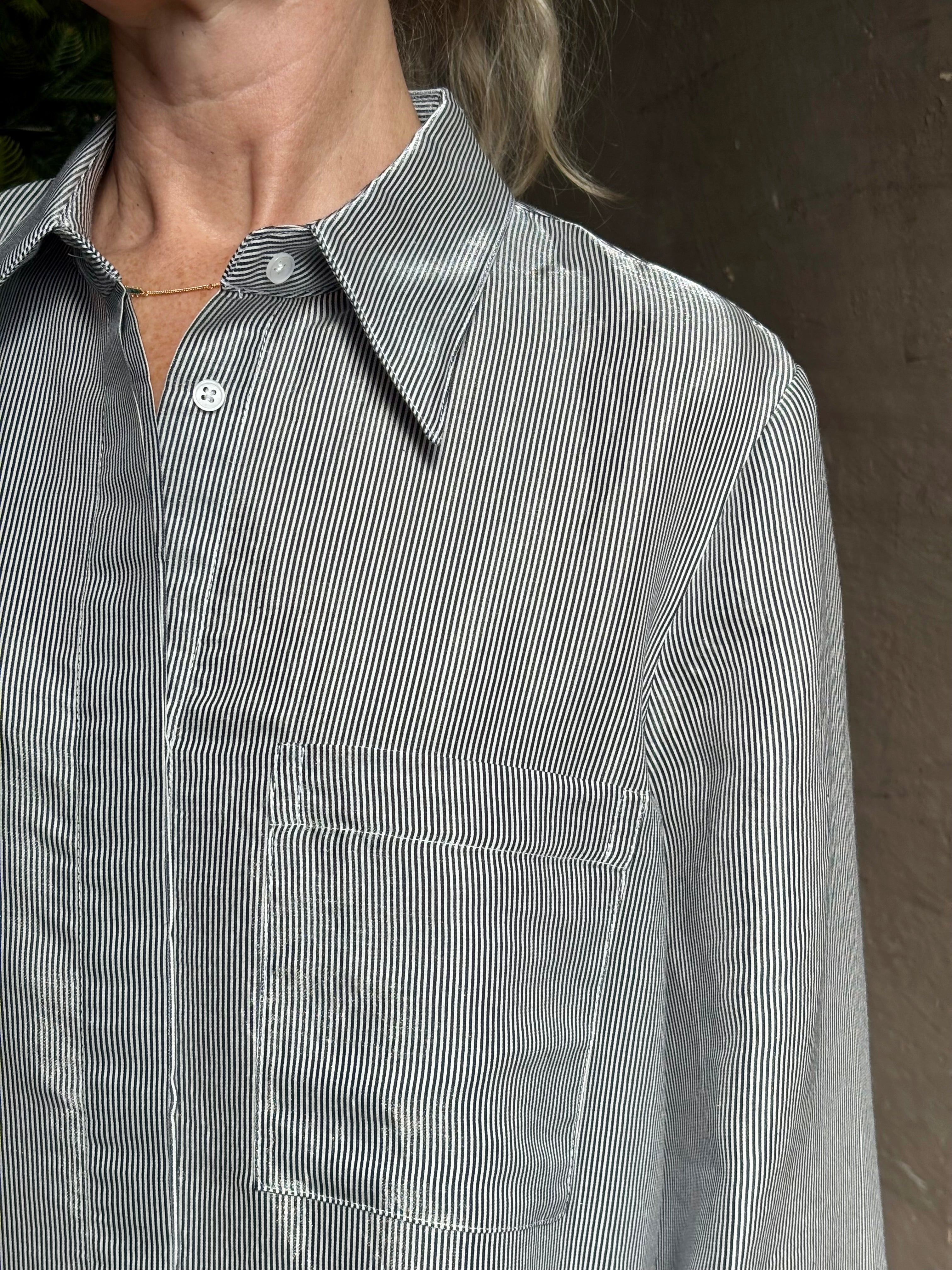 Mature woman wearing luxury Jenny's Gown from designer TWP rendered in a lumines white and blue stripe print and crafted in USA from a viscose and lorex blend this lightweight long sleeve maxi  dress drapes beautifully with a flowing quality that moves with understated grace 