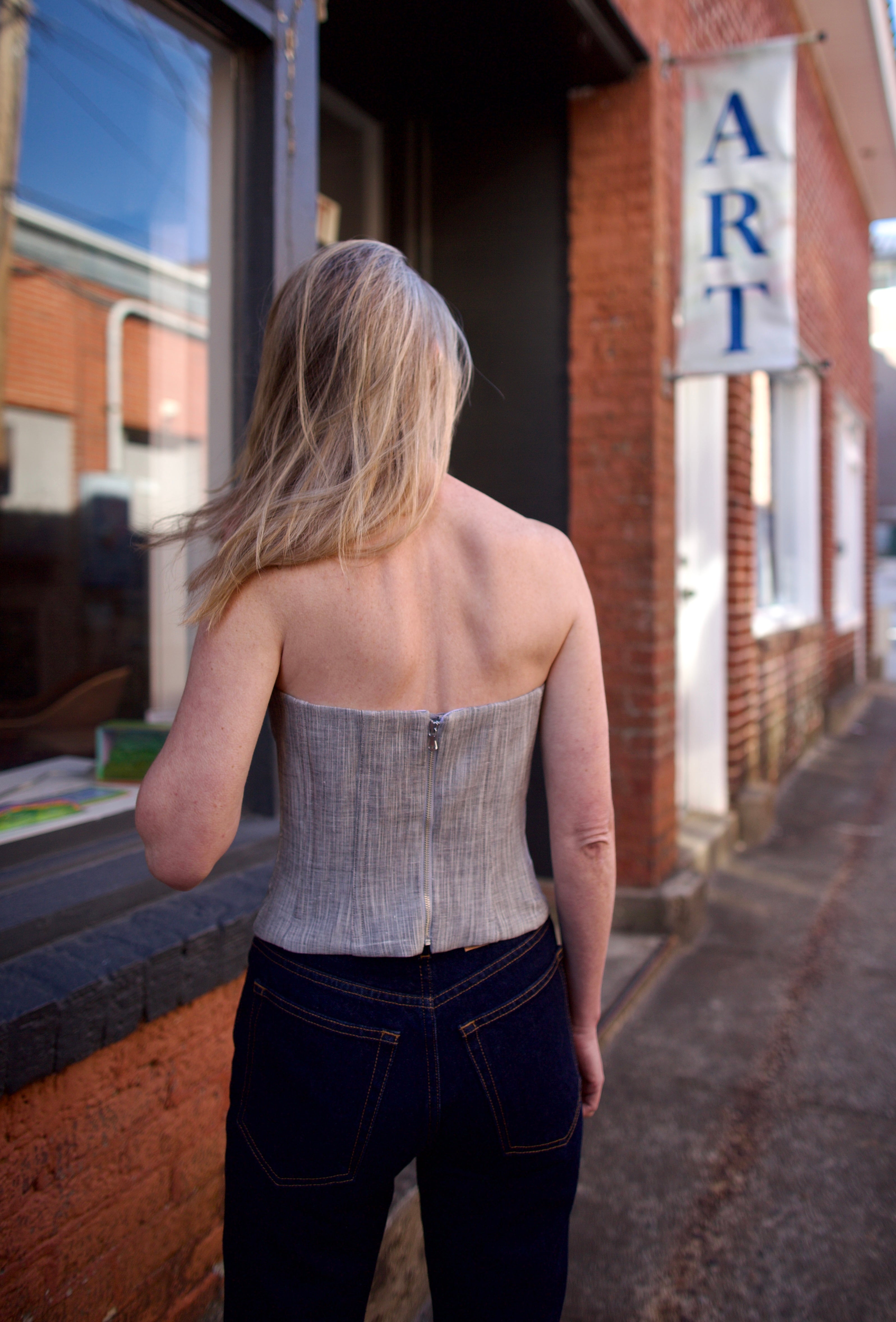 Mature woman wearing luxury brand TWP Jillian cotton-wool bustier in heather grey with bust darts zip closure 